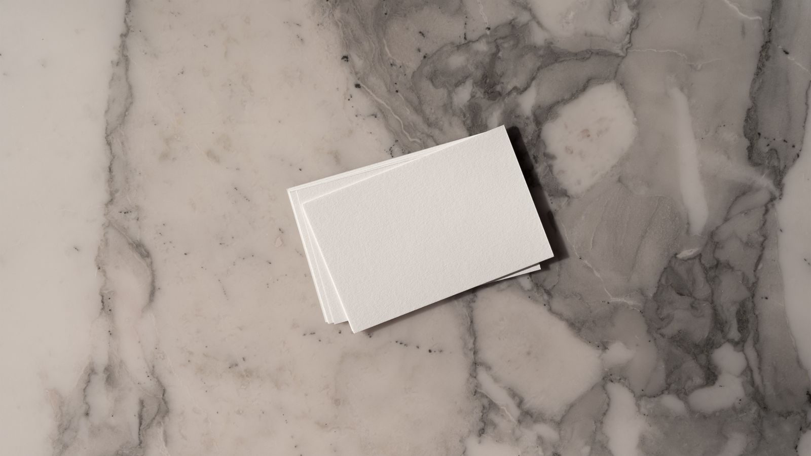 Pilha de cartões de visita em branco sobre fundo de mármore, ideal para mockups