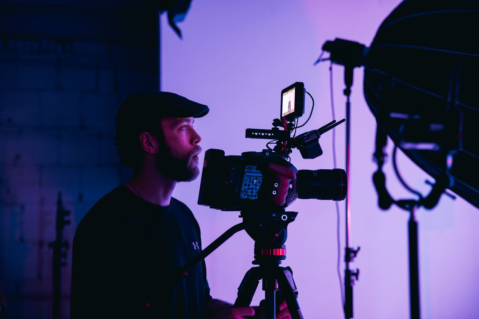 Diretor de fotografia concentrado ajustando a câmera para uma gravação em estúdio