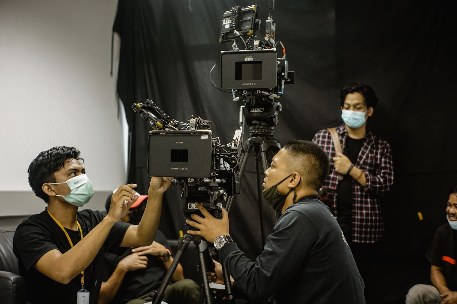 Equipe de cinegrafistas montando equipamento de câmera profissional em um estúdio