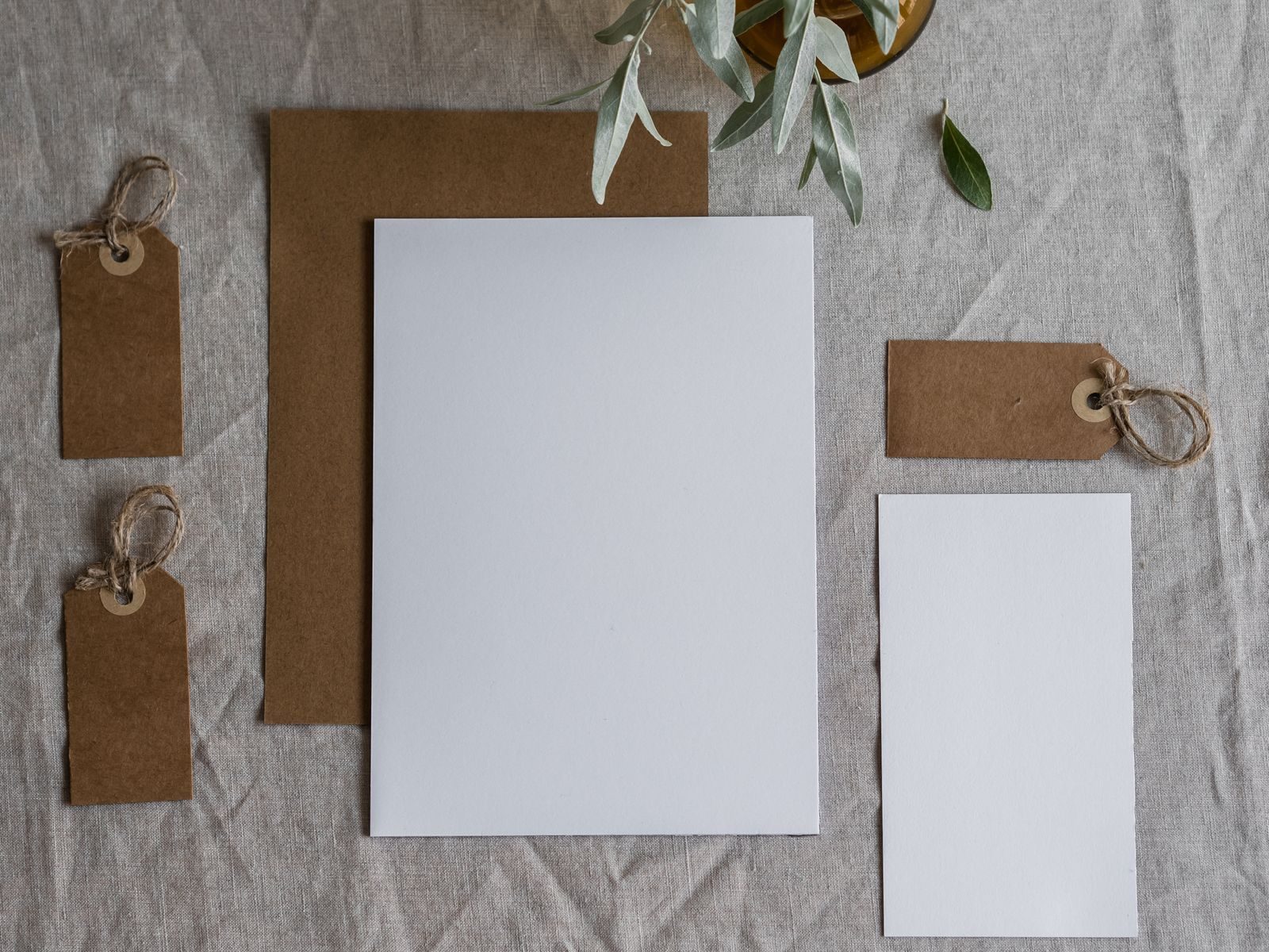 Flat lay de papelaria em branco com etiquetas kraft sobre tecido de linho, ideal para mockup