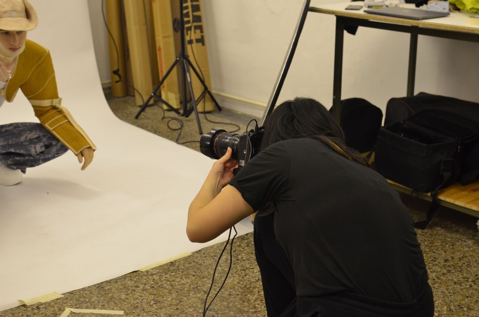 Vista do alto de fotógrafo com câmera fotografando modelo em ensaio de moda no estúdio