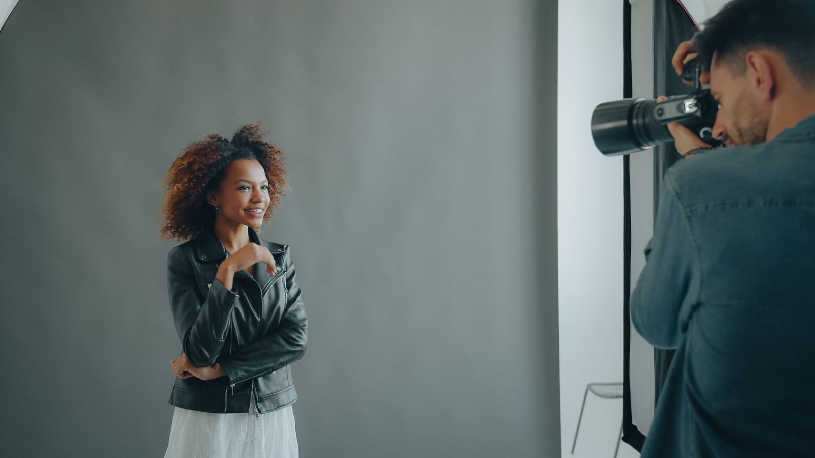 Fotógrafo fotografando uma modelo durante sessão em estúdio