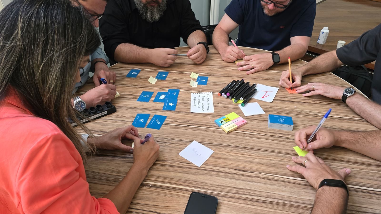 Equipe diversa em brainstorming com cartões e post-its em mesa redonda