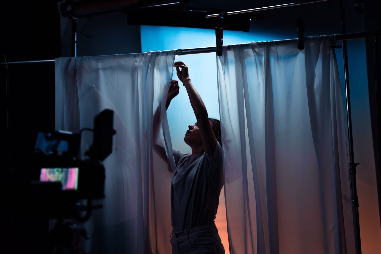 Mulher ajustando cortinas em um set de filmagem