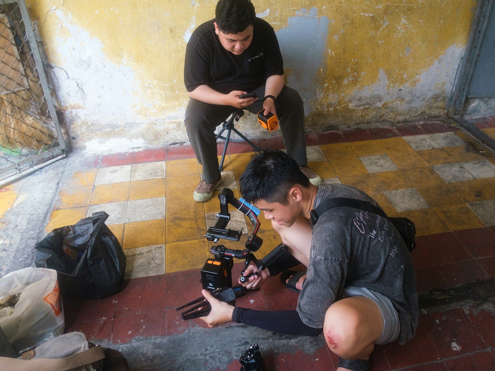 Dois homens trabalhando com equipamento de câmera em ambiente interno