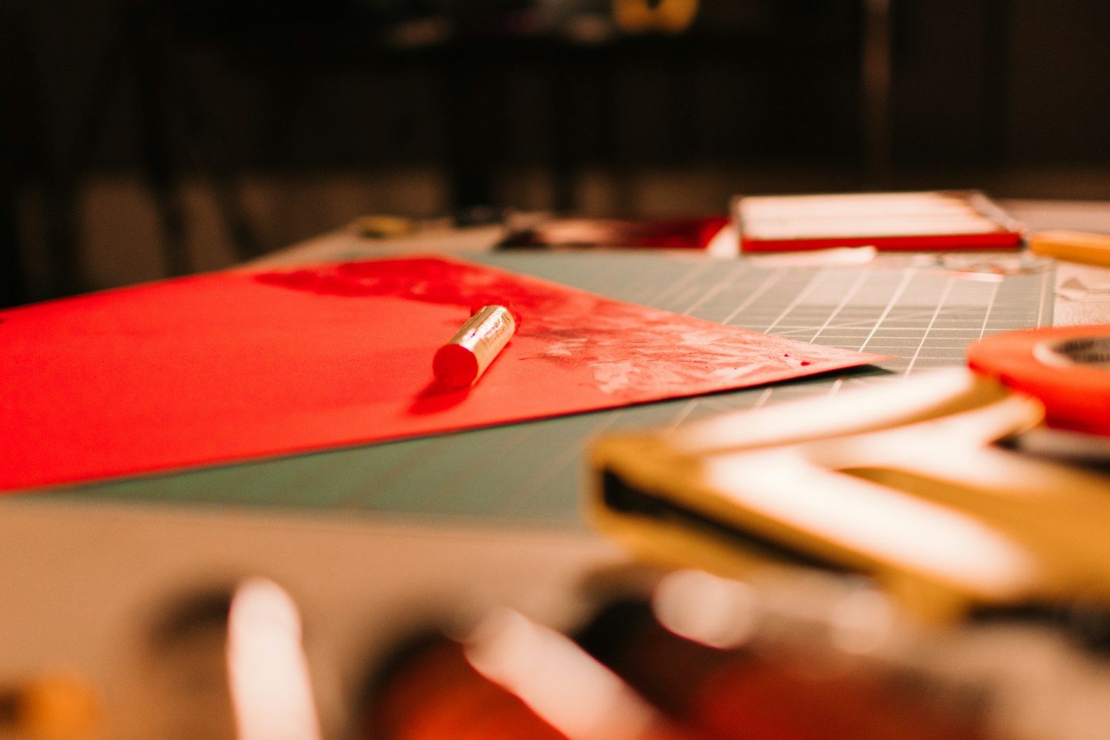 Ferramentas de artesanato em uma bancada com papel vermelho