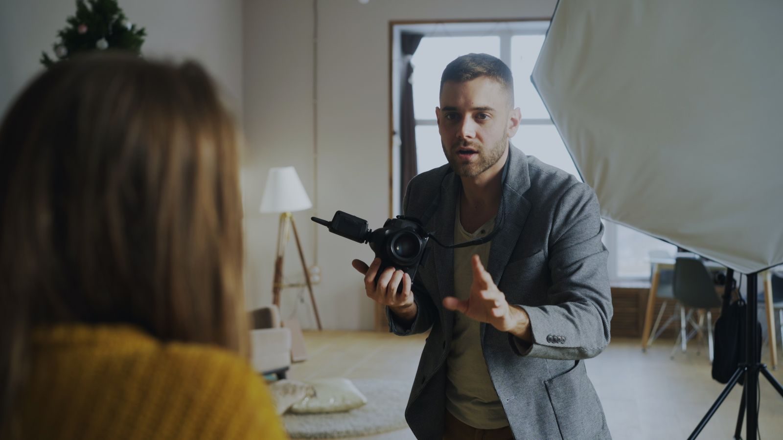 Fotógrafo orientando modelo em sessão no estúdio com iluminação profissional