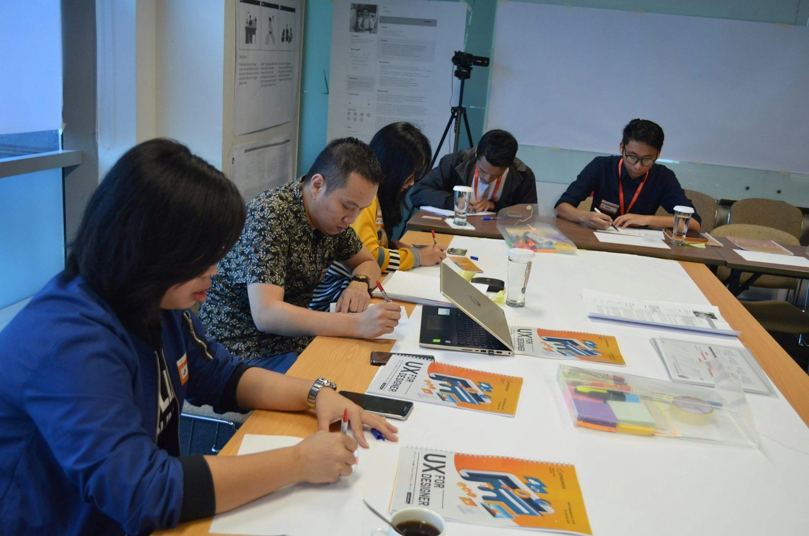 Grupo de pessoas sentadas à mesa trabalhando em um projeto