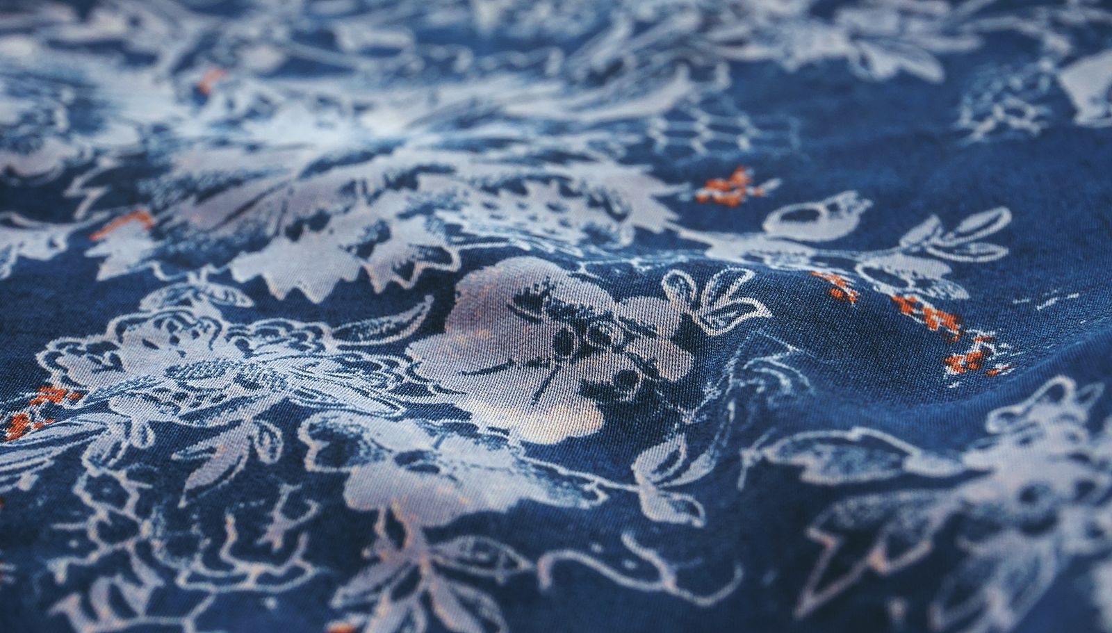 Close de tecido azul com estampa floral branca detalhada