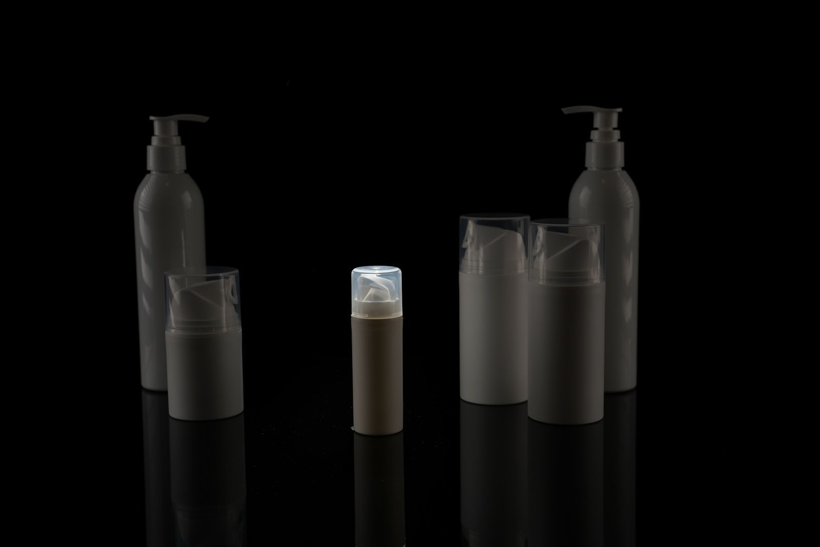 Coleção de frascos de cosméticos vazios sobre fundo preto, em estilo minimalista
