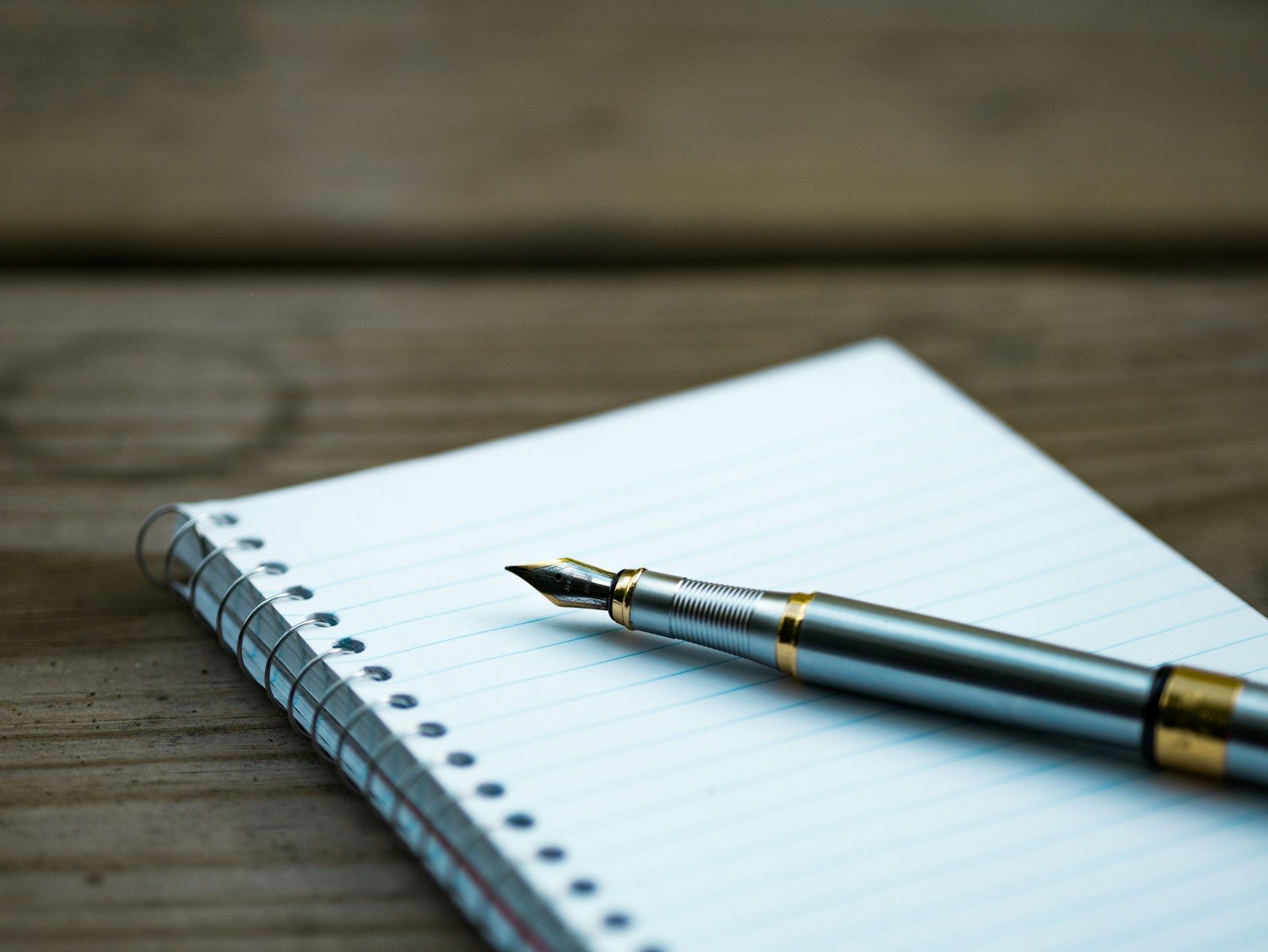 Caneta-tinteiro sobre caderno espiral