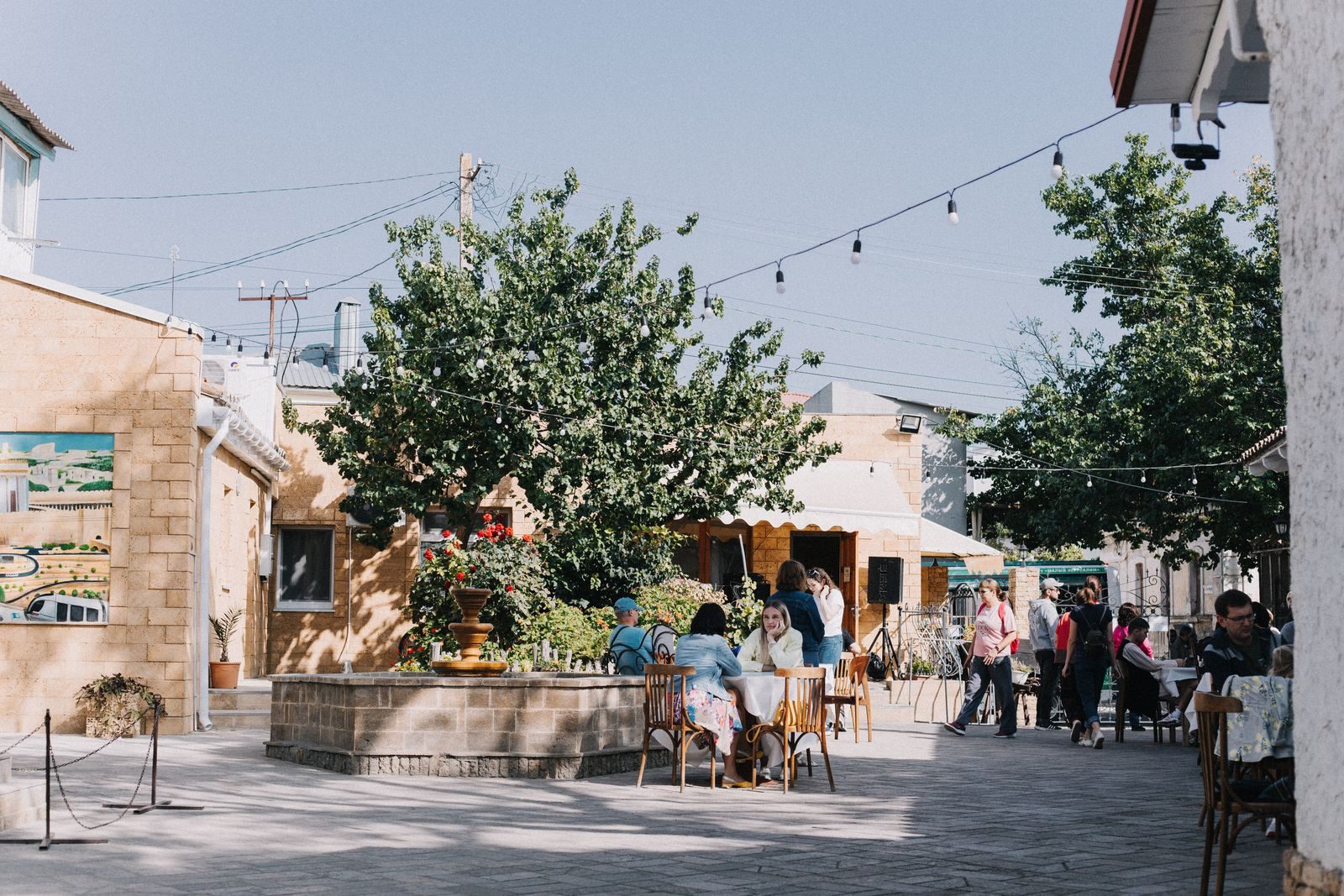 Pessoas aproveitando o clima animado de um café ao ar livre em dia de sol