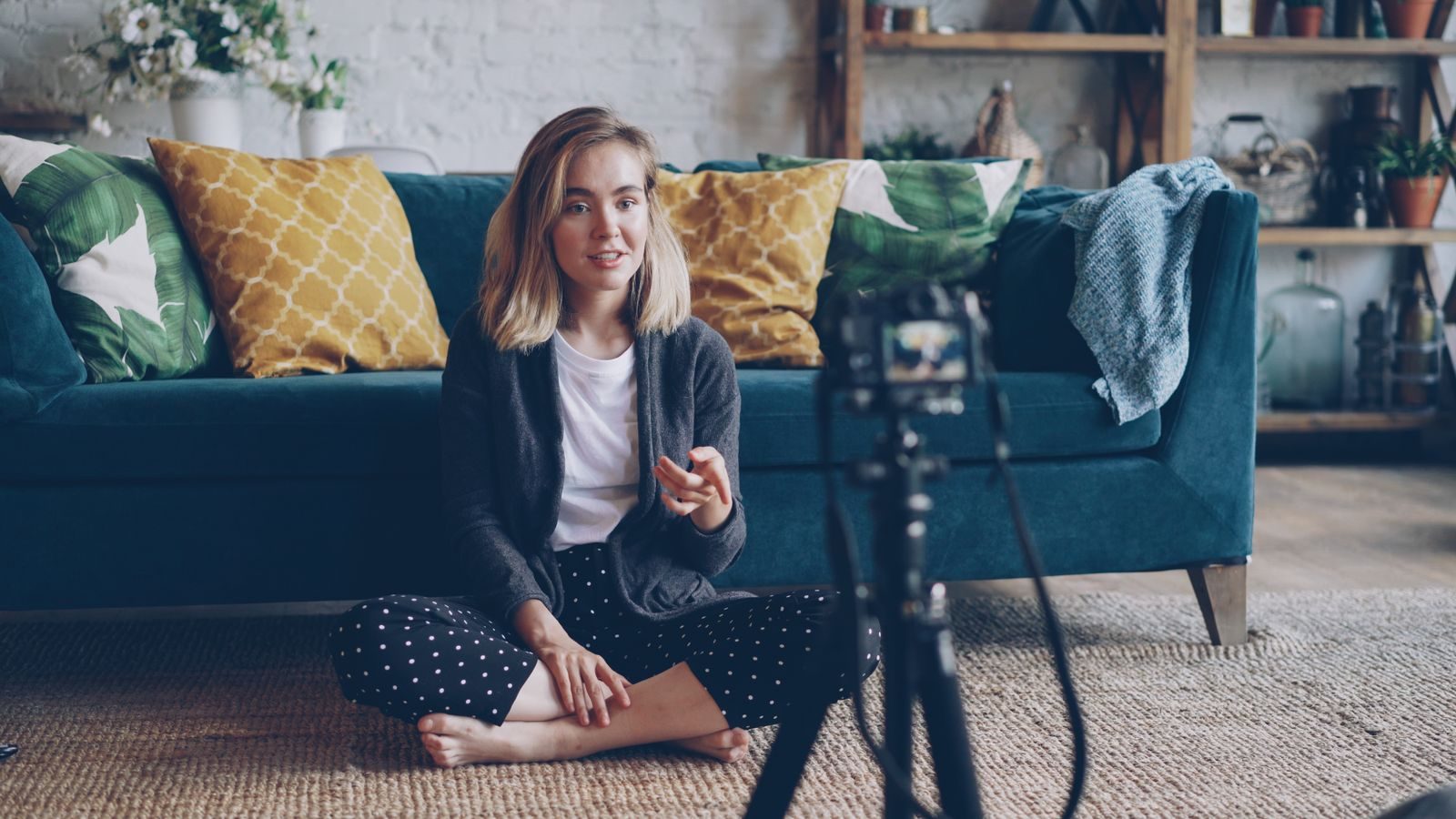 Jovem gravando um vlog em sua sala aconchegante com uma câmera montada