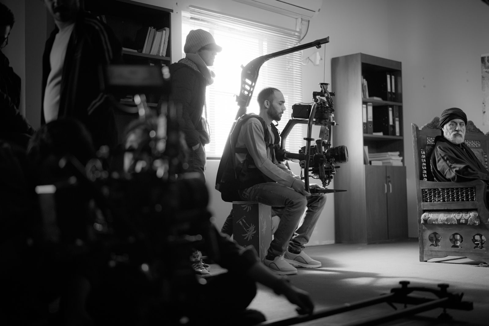 Foto em preto e branco de uma equipe de filmagem trabalhando em ambiente interno com câmeras de ponta