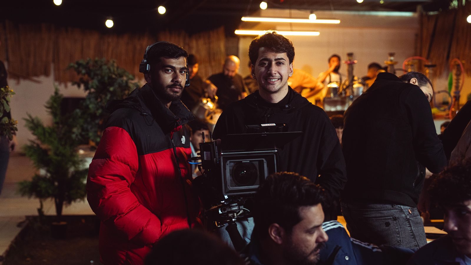 Equipe de câmera filmando uma cena em ambiente interno aconchegante com equipamento profissional