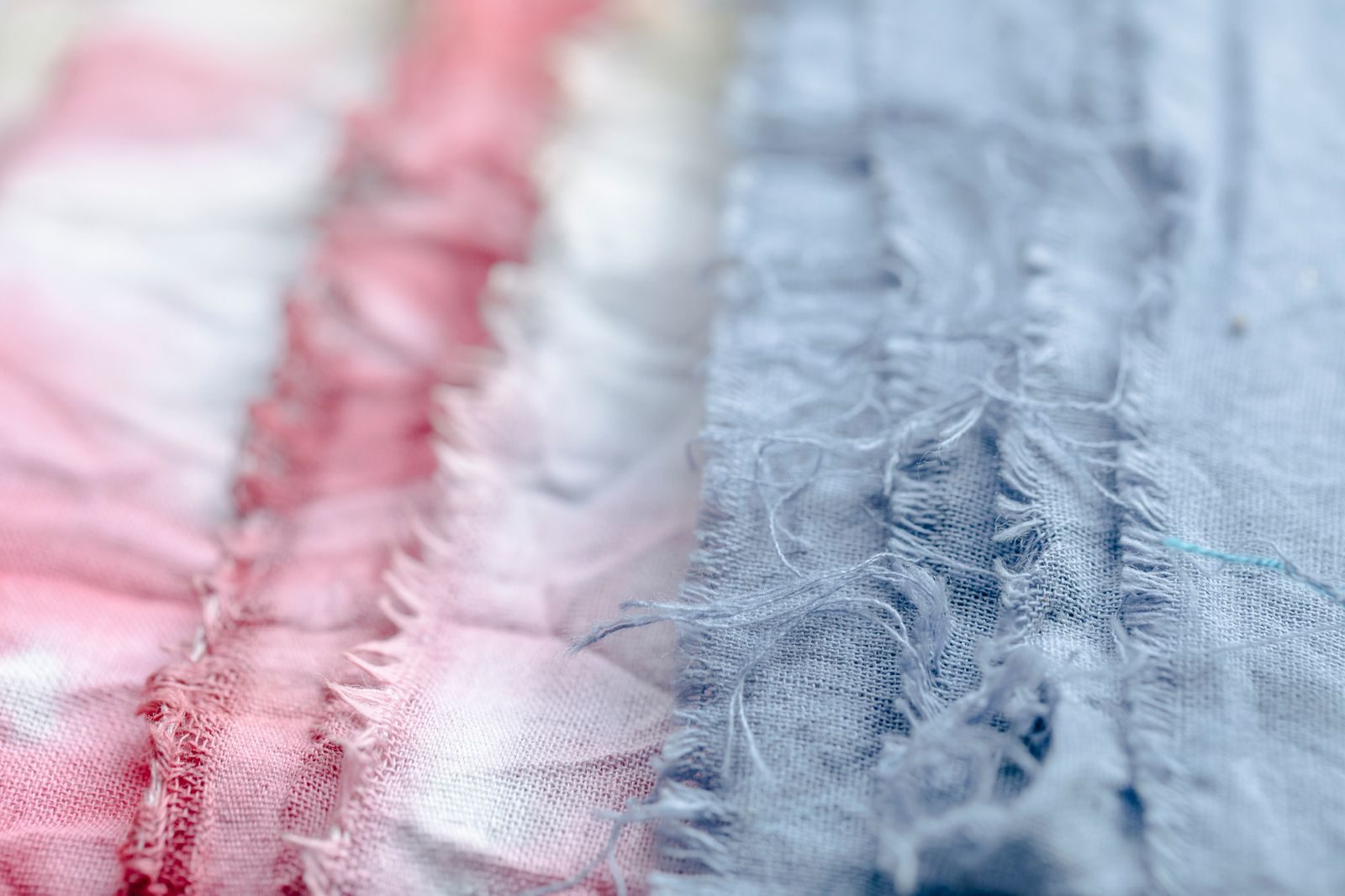 Tecido azul e rosa com linhas sobre uma superfície em estúdio profissional de confecção, com fundo desfocado