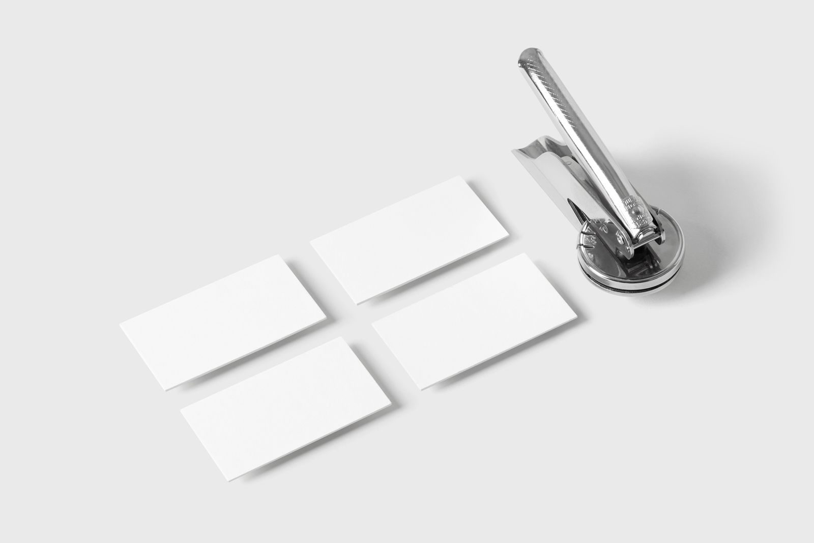 Gravador de relevo elegante com cartões de visita em branco sobre fundo branco