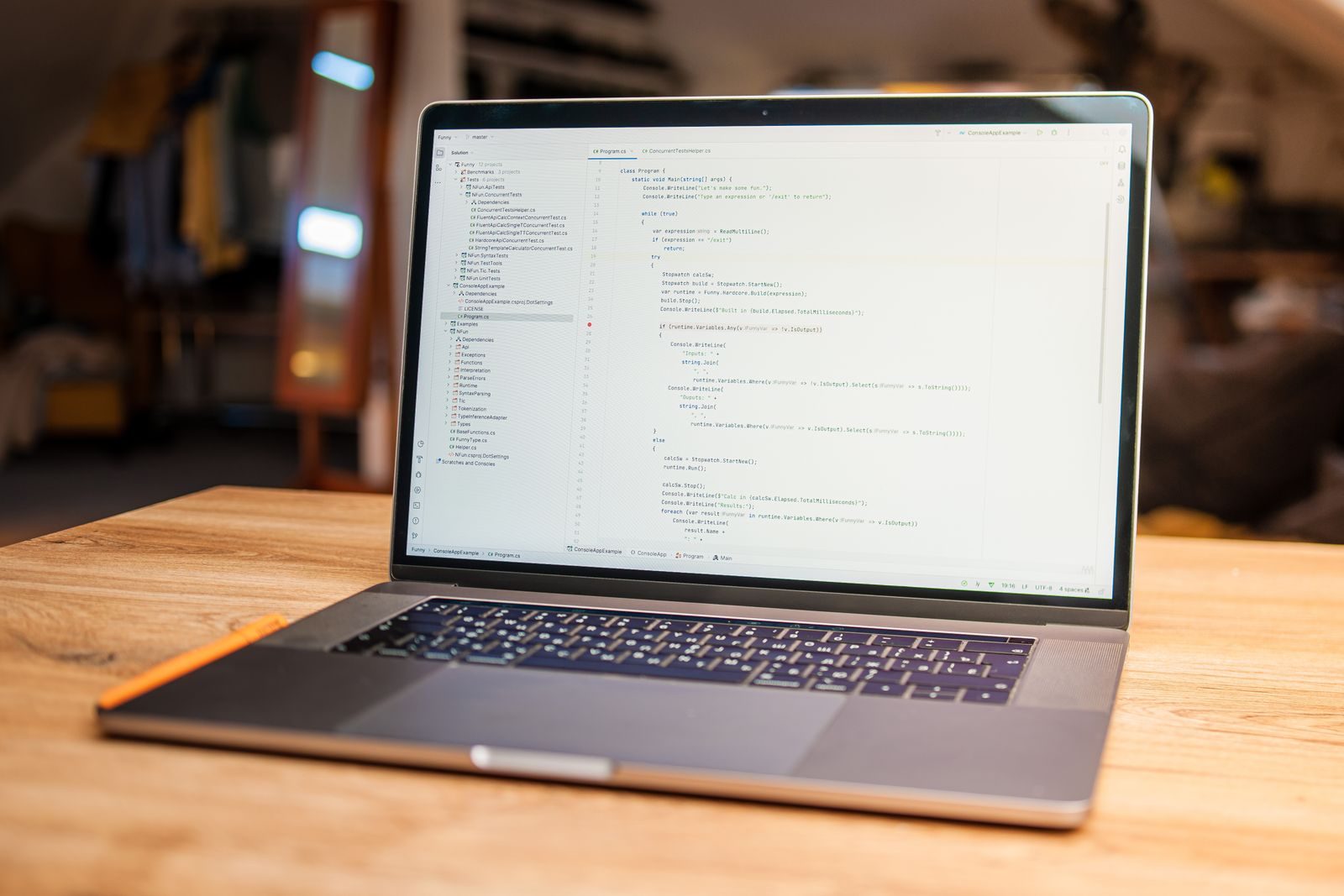 Notebook aberto exibindo código sobre mesa de madeira em um espaço de trabalho moderno e aconchegante
