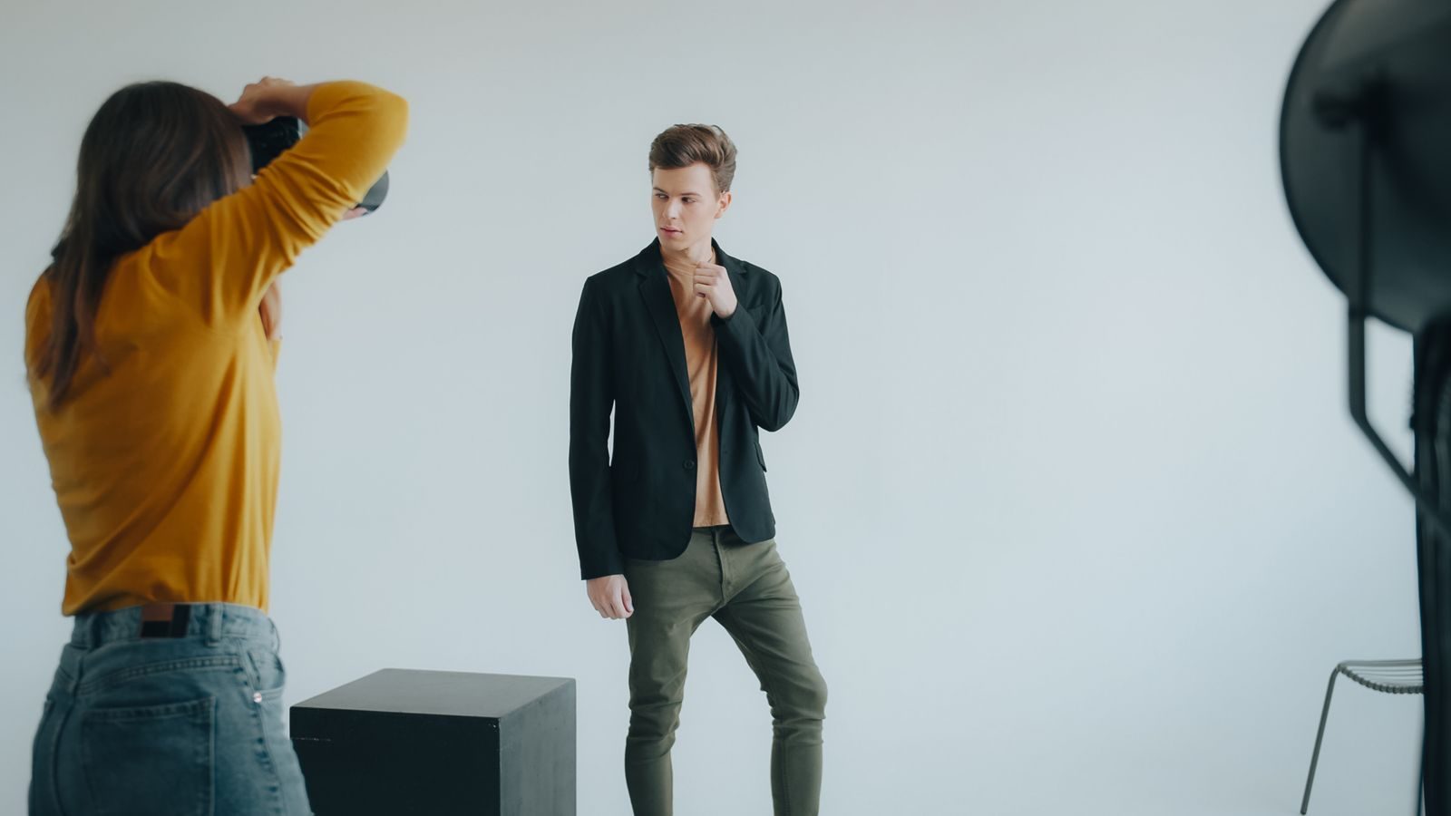 Fotógrafo fotografando modelo masculino em estúdio moderno