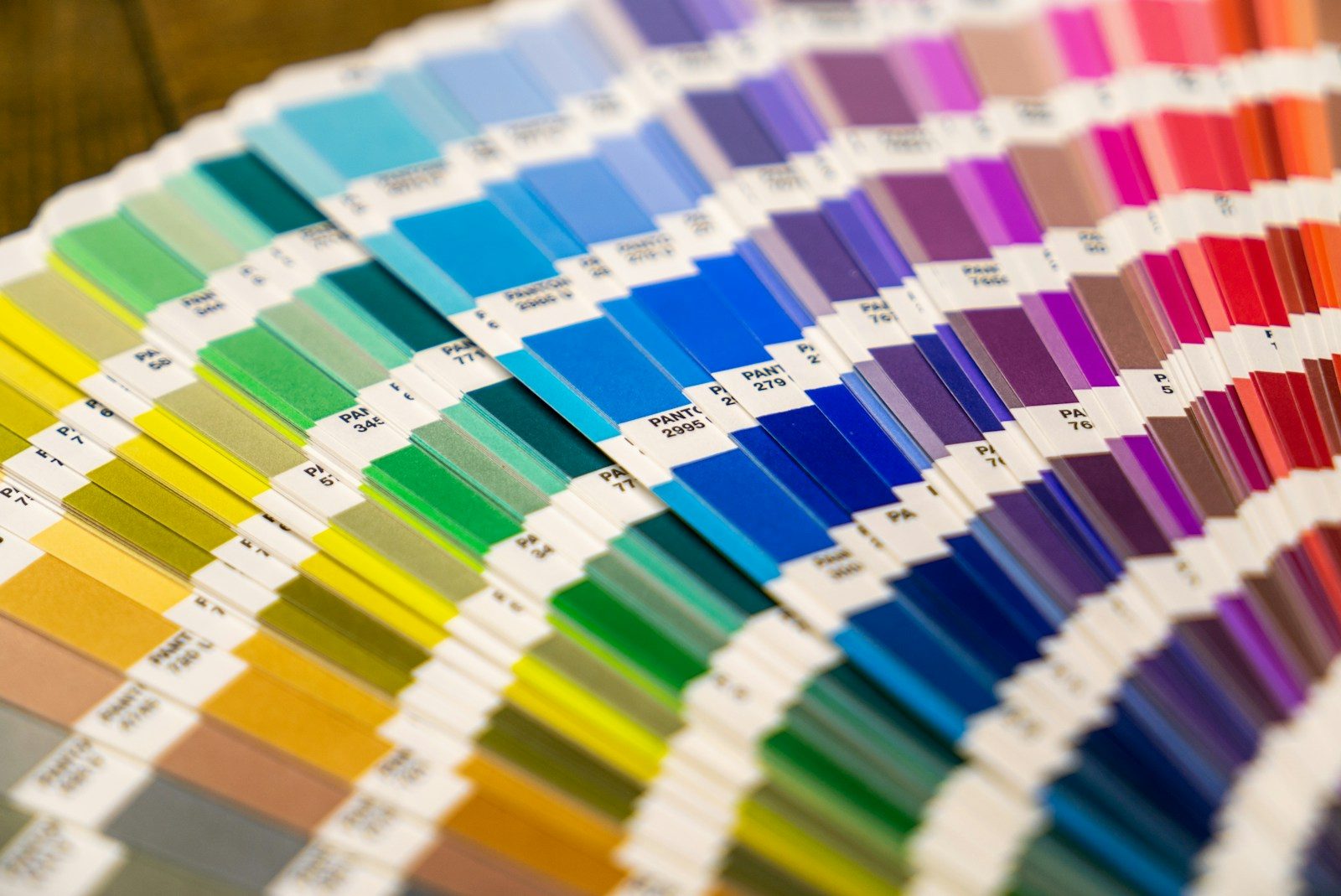 Leque de amostras de papel coloridas dispostas em espectro sobre uma superfície
