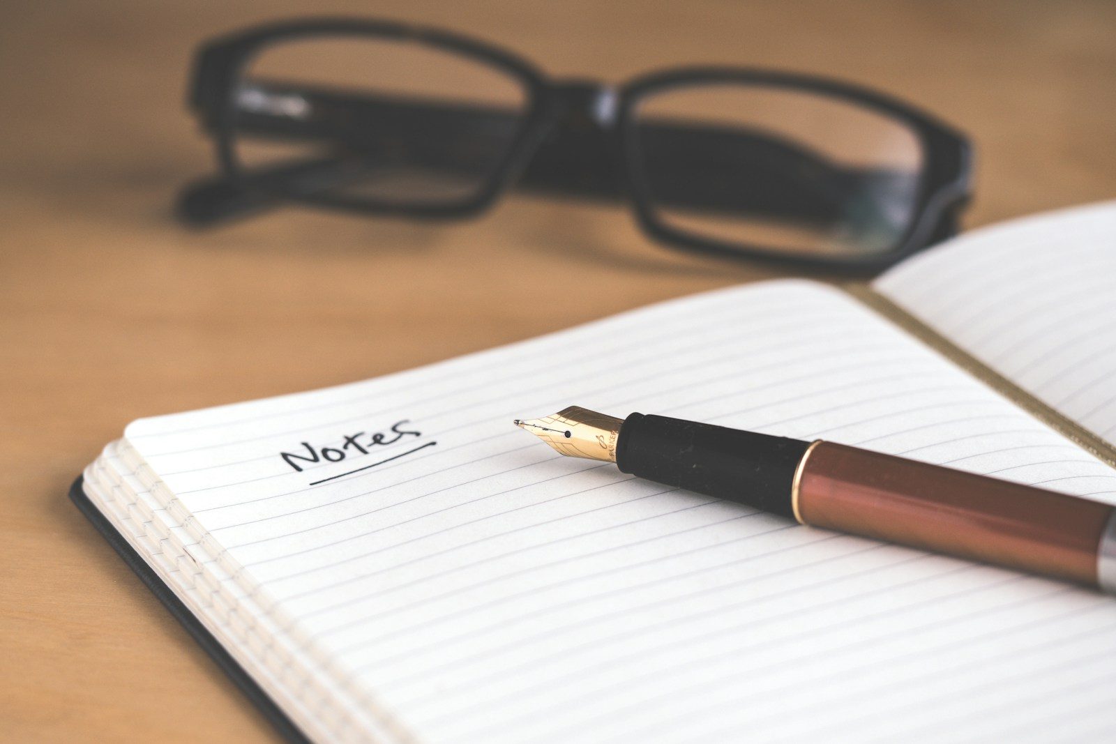 Caneta-tinteiro marrom sobre caderno