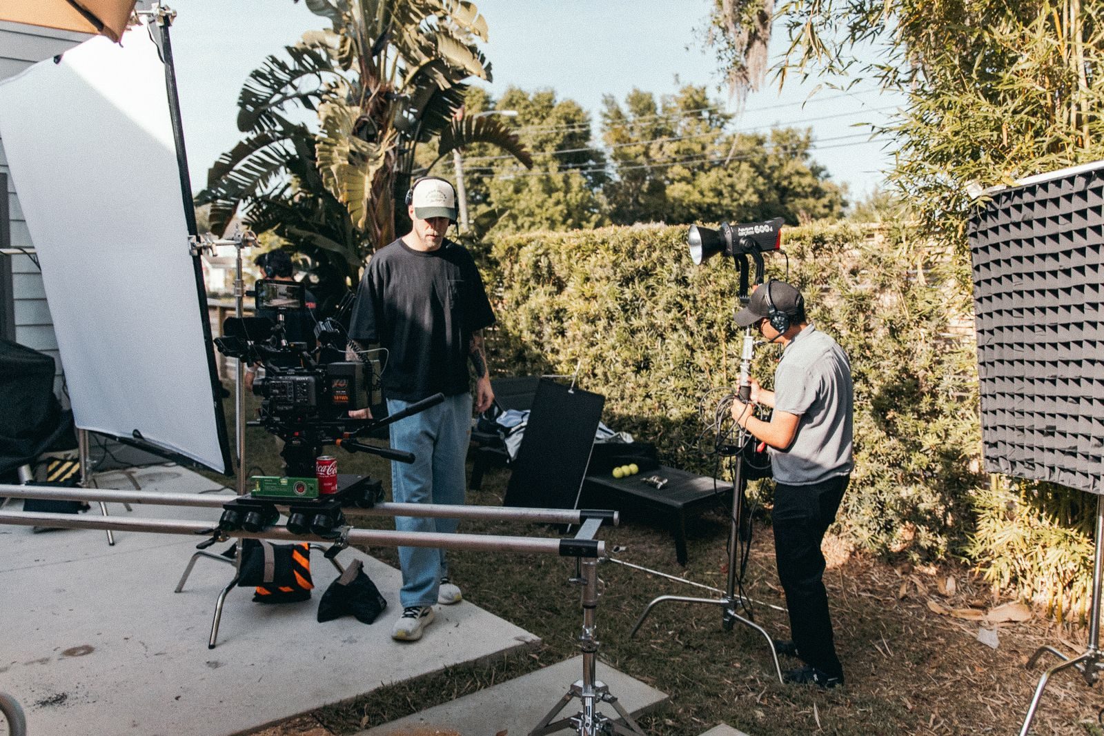 Equipe de filmagem montando luzes e câmera ao ar livre em meio à vegetação exuberante