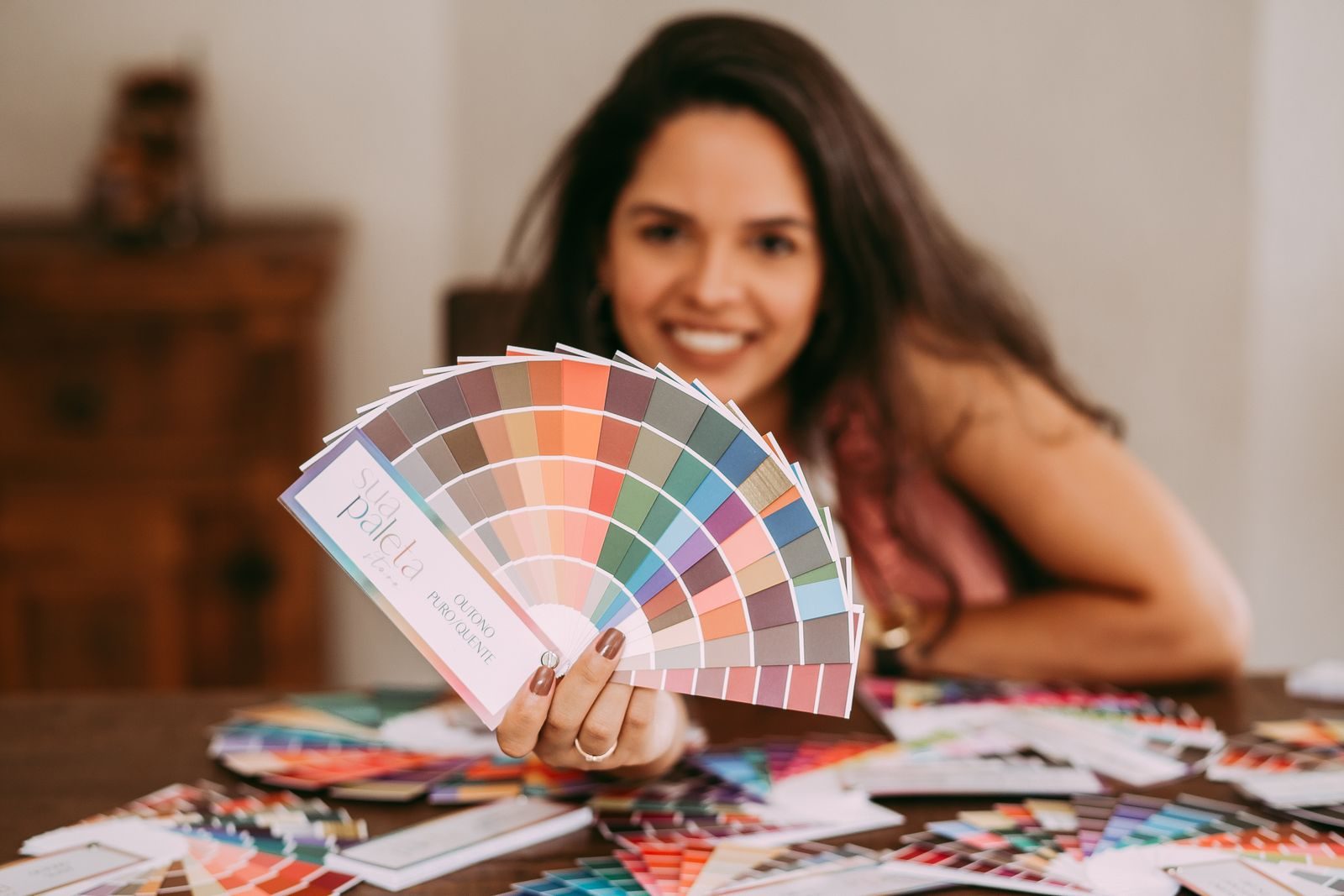 Mulher sorridente mostrando uma paleta de cores vibrantes