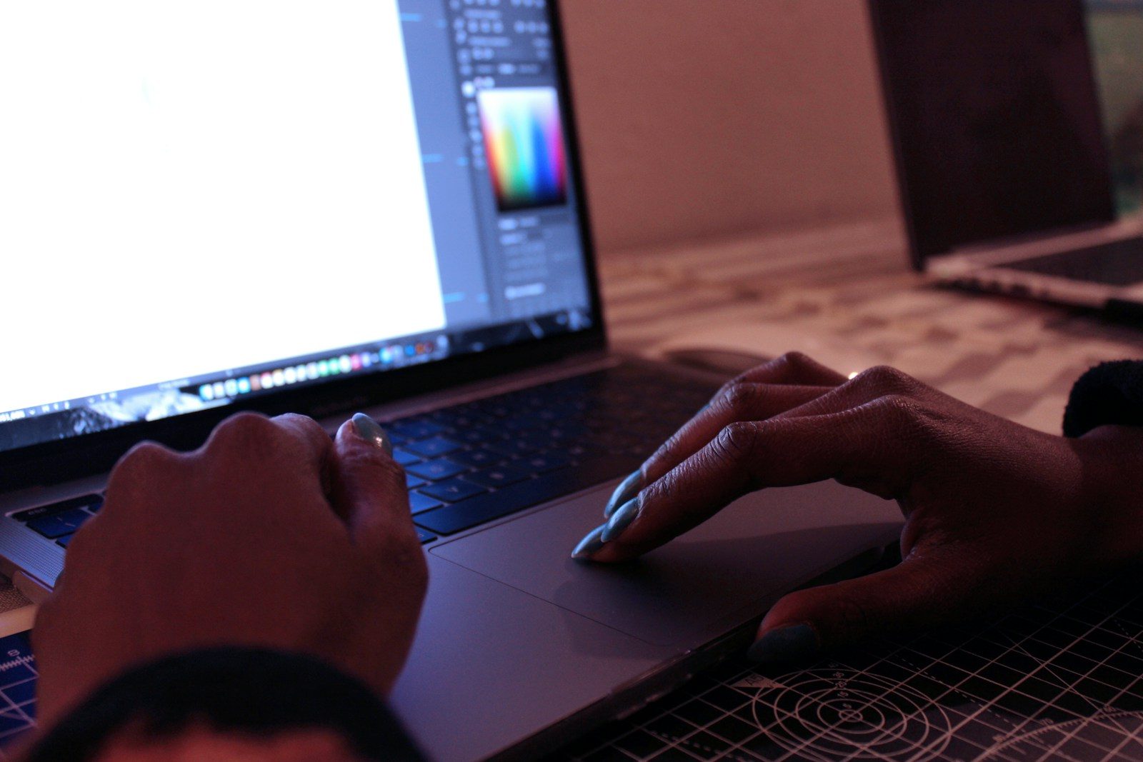 Pessoa usando MacBook Pro sobre mesa de madeira marrom