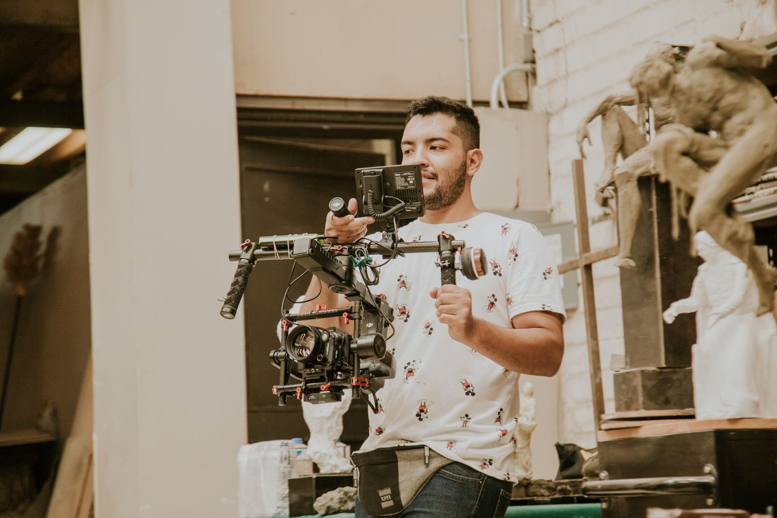 Cinegrafista usando um estabilizador profissional em ambiente interno durante os bastidores
