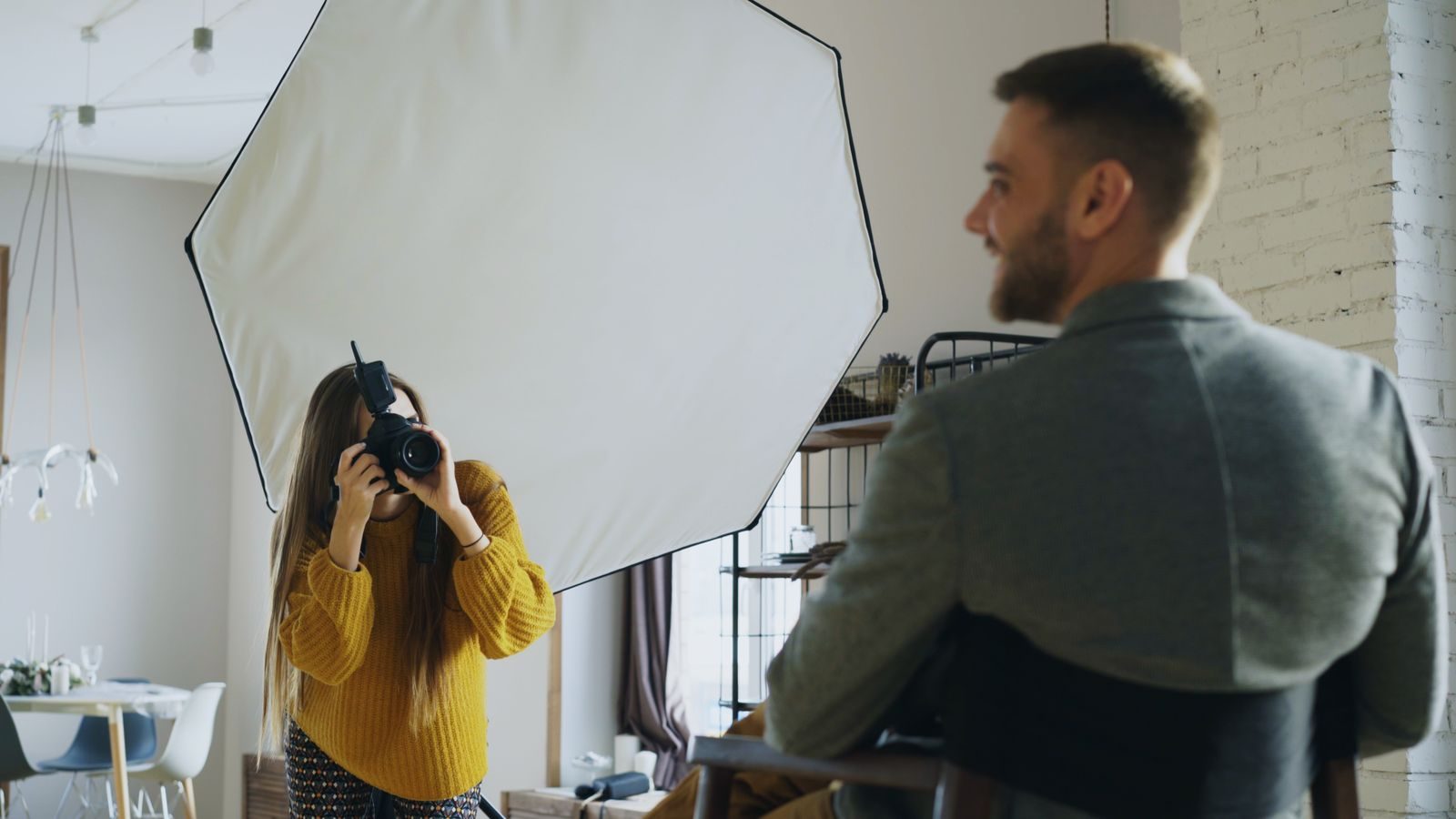 Fotógrafo profissional faz retrato em ambiente interno com softbox para um cliente