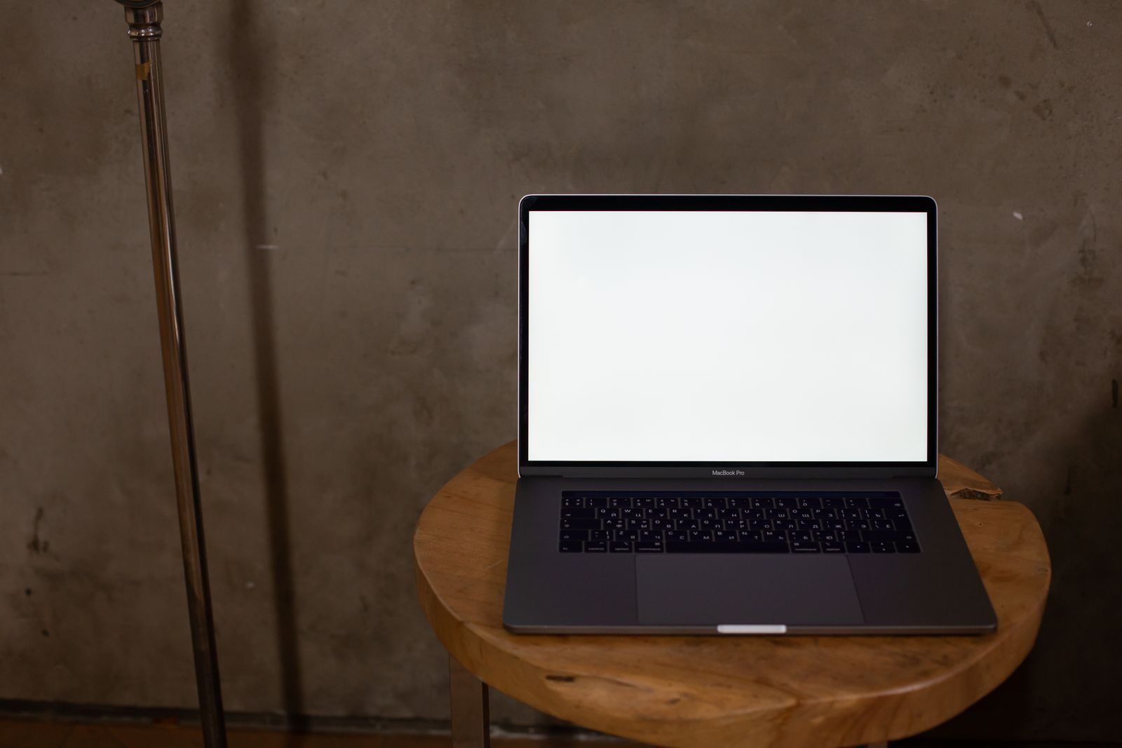 Notebook com tela em branco sobre mesa de madeira, ideal para mockups e projetos de design
