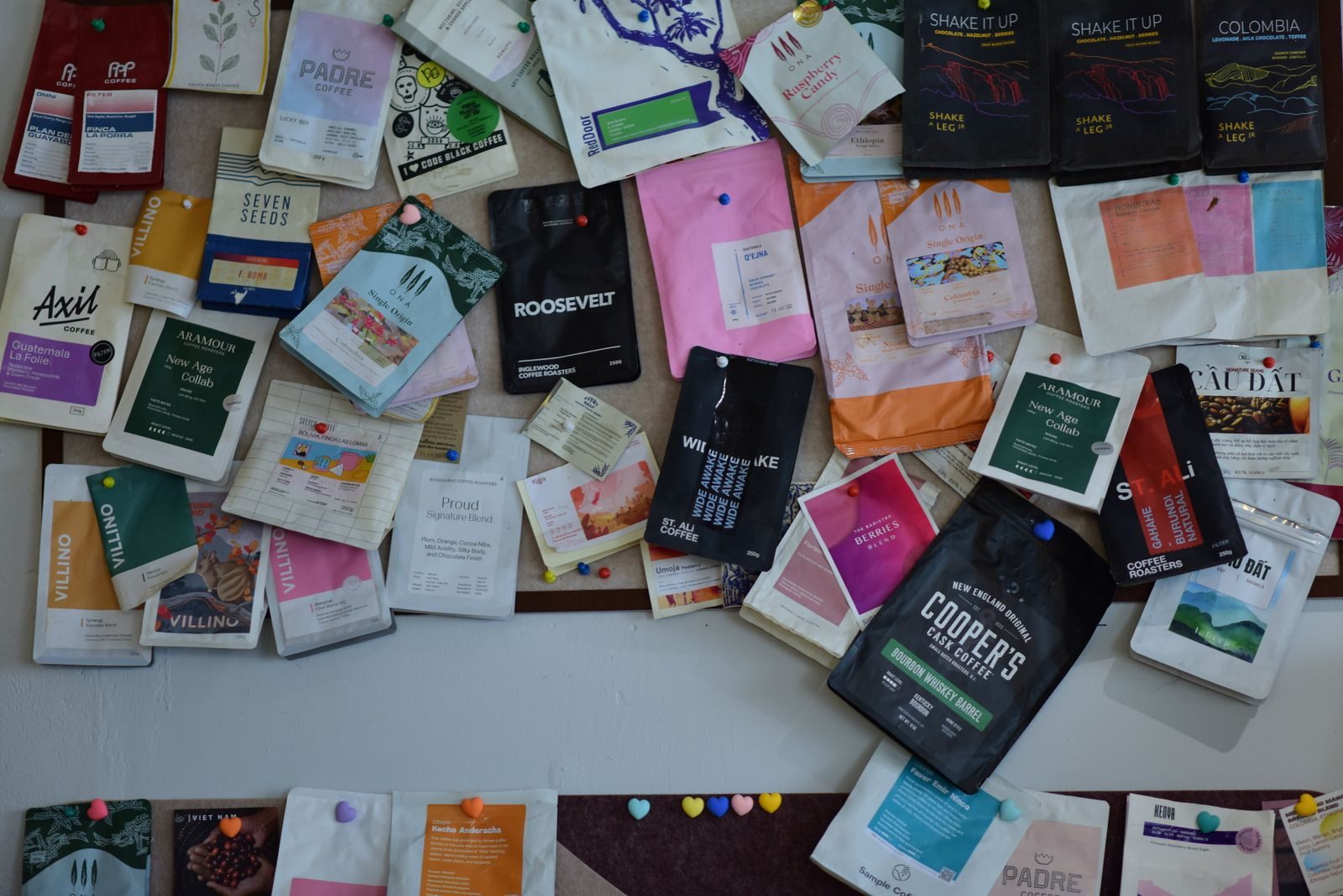 Coleção vibrante de embalagens de café variadas expostas na parede, destacando o design