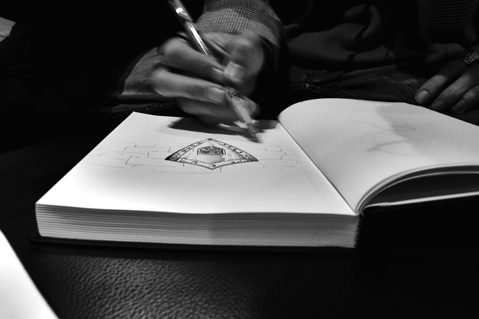 Pessoa desenhando em um caderno com caneta