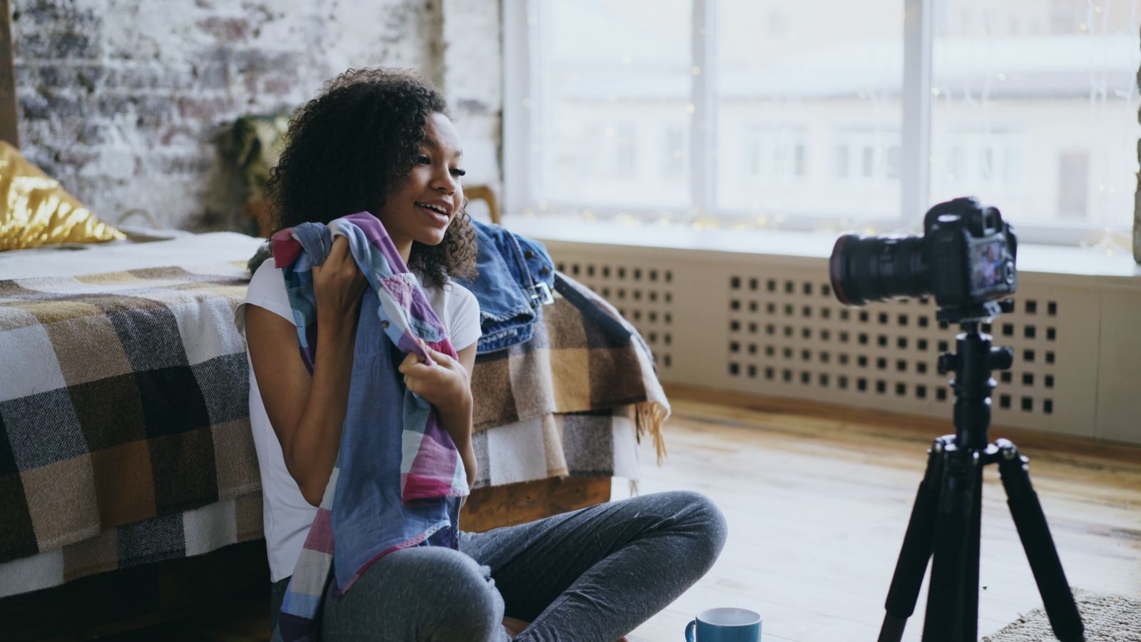 Jovem gravando um vlog de moda em quarto aconchegante, no estilo de vida de influenciadora