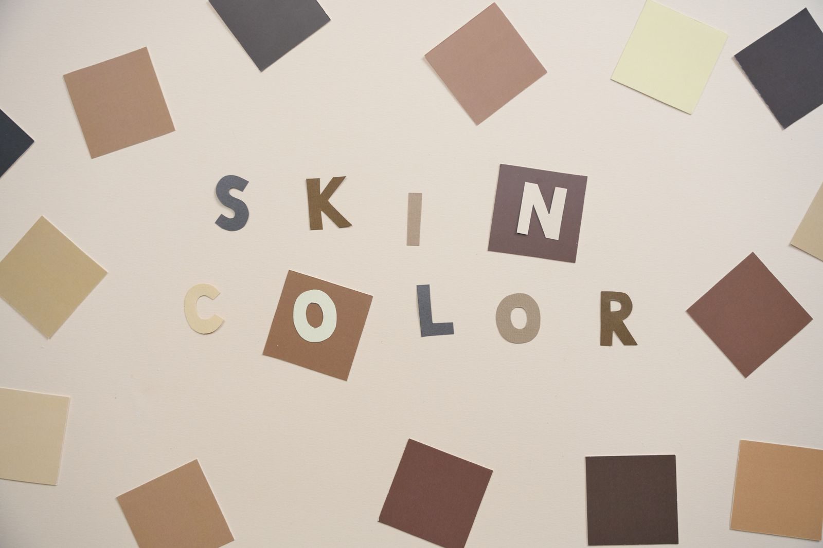 Representação artística da diversidade com quadrados de papel colorido e tipografia