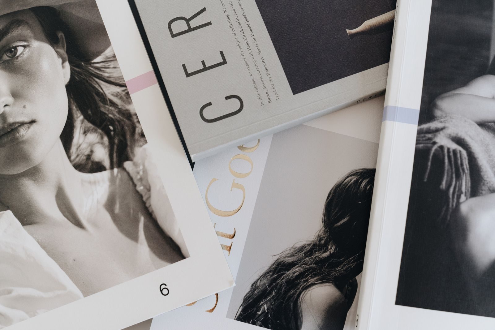 Close de revistas de arte e moda espalhadas sobre uma mesa