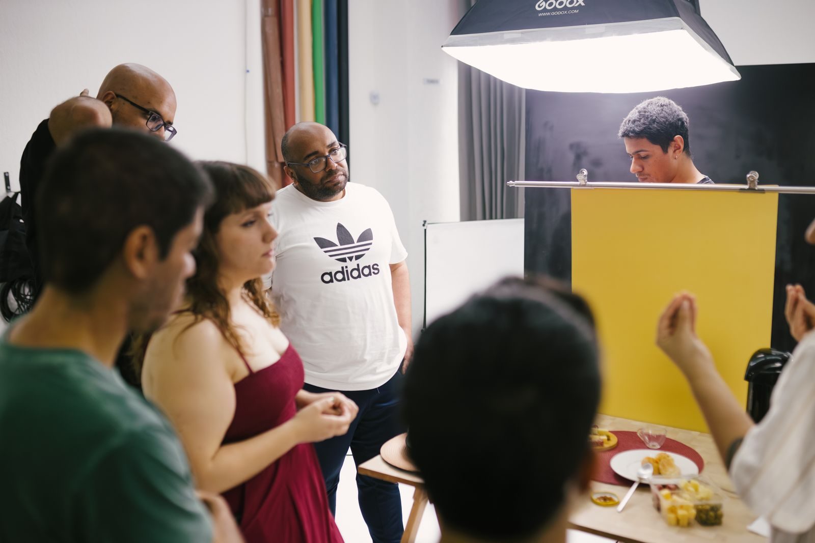 Grupo de fotógrafos trabalhando juntos em estúdio com equipamentos de iluminação