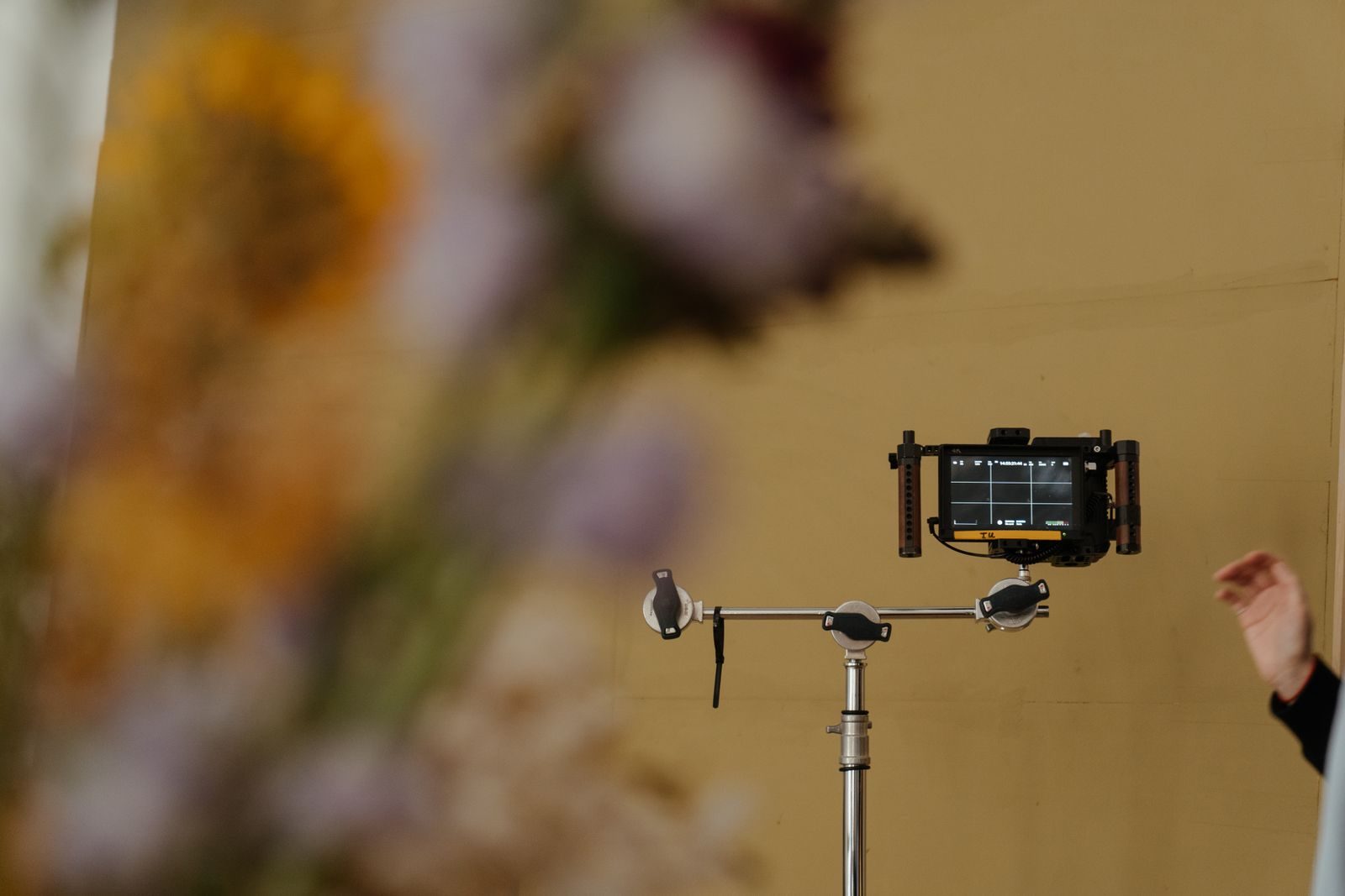 Câmera profissional montada com flores em primeiro plano, dando um toque artístico