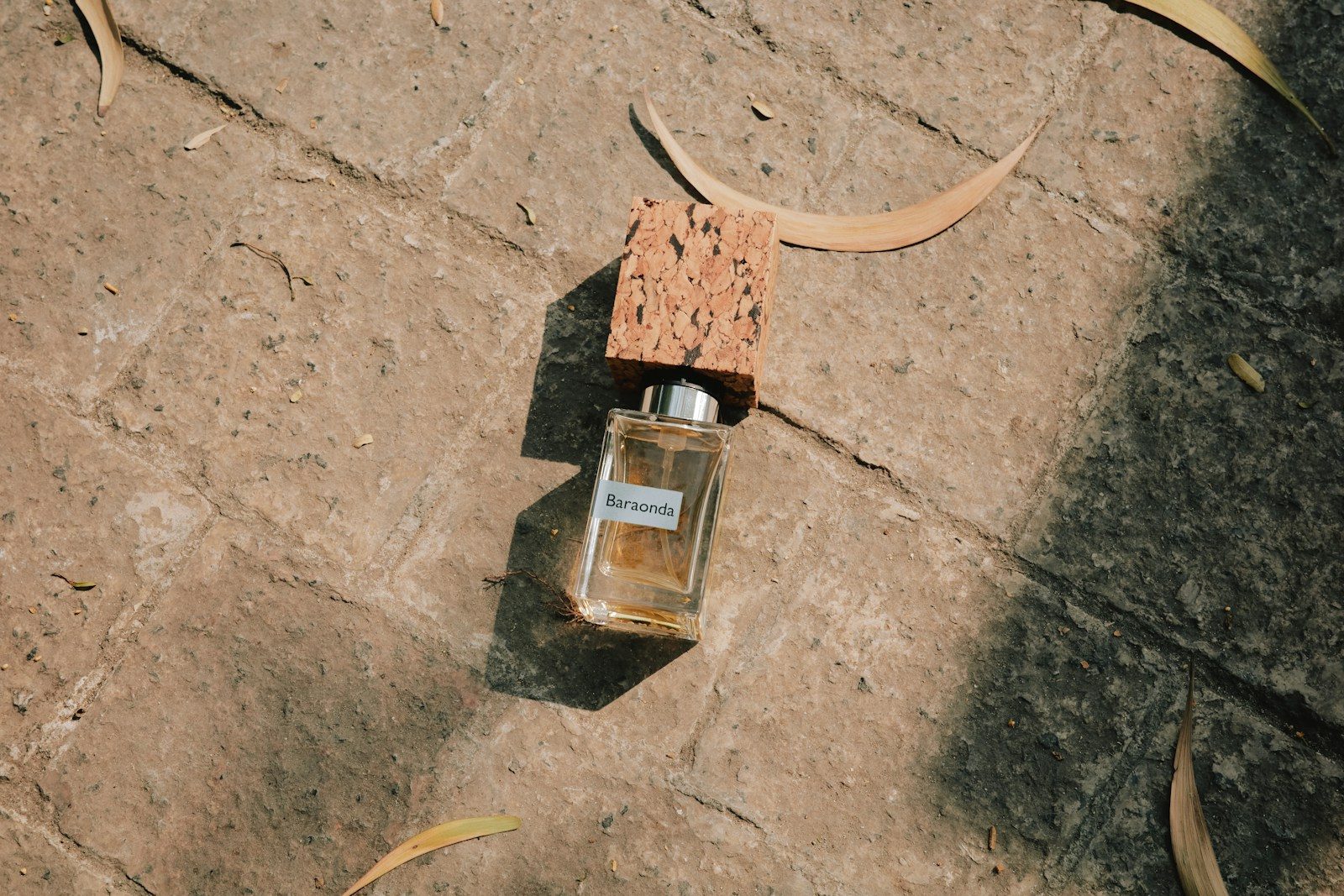 Frasco de perfume com tampa de cortiça sobre uma pedra