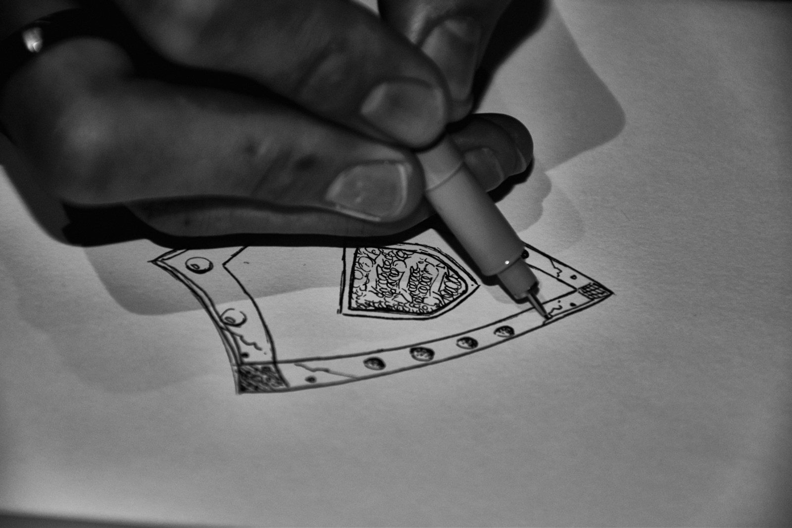 Artista desenhando um padrão detalhado no papel com caneta