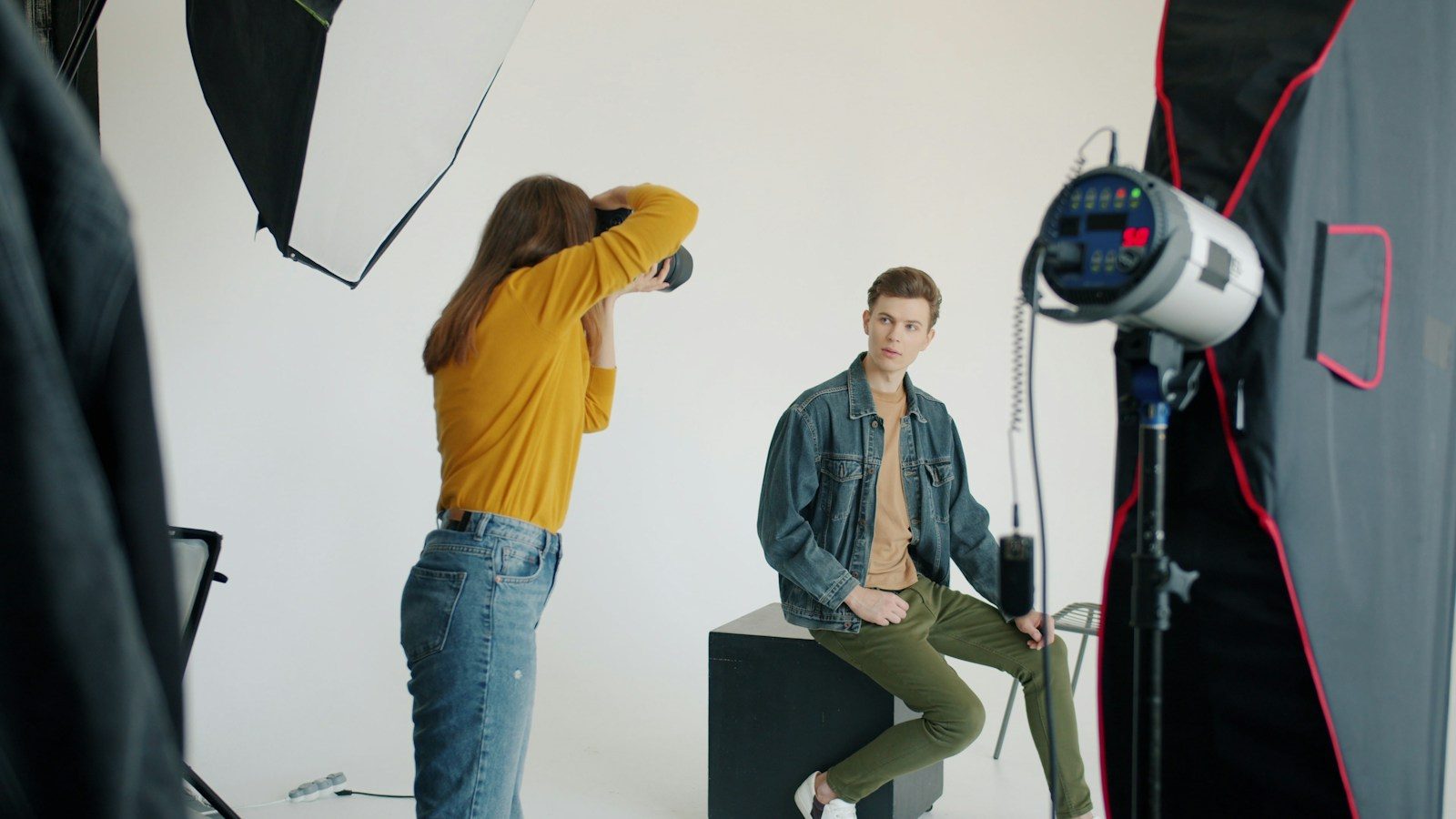 Fotógrafo orientando modelo durante sessão de fotos em estúdio