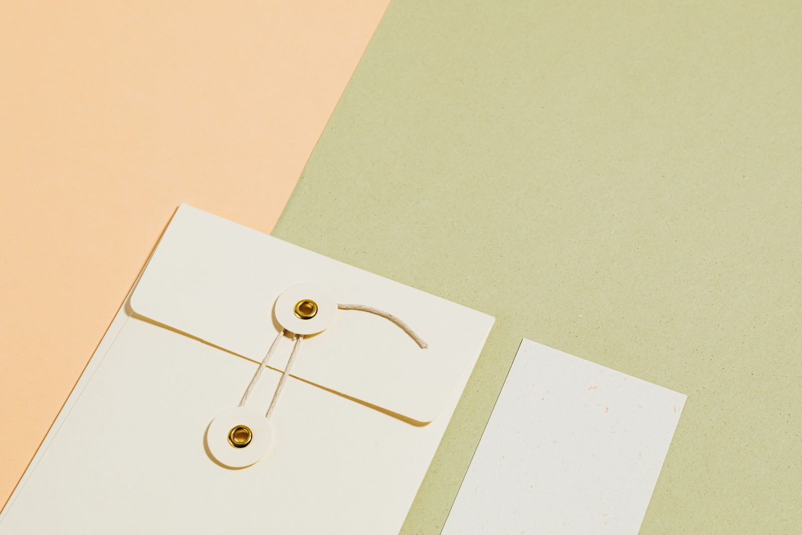 Flat lay minimalista de papelaria com envelope e cartão sobre fundo pastel
