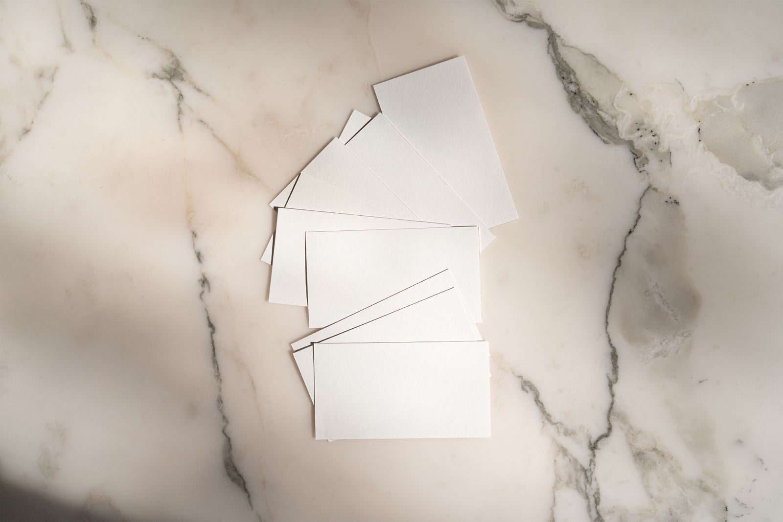Flat lay de cartões brancos em branco dispostos sobre fundo de mármore