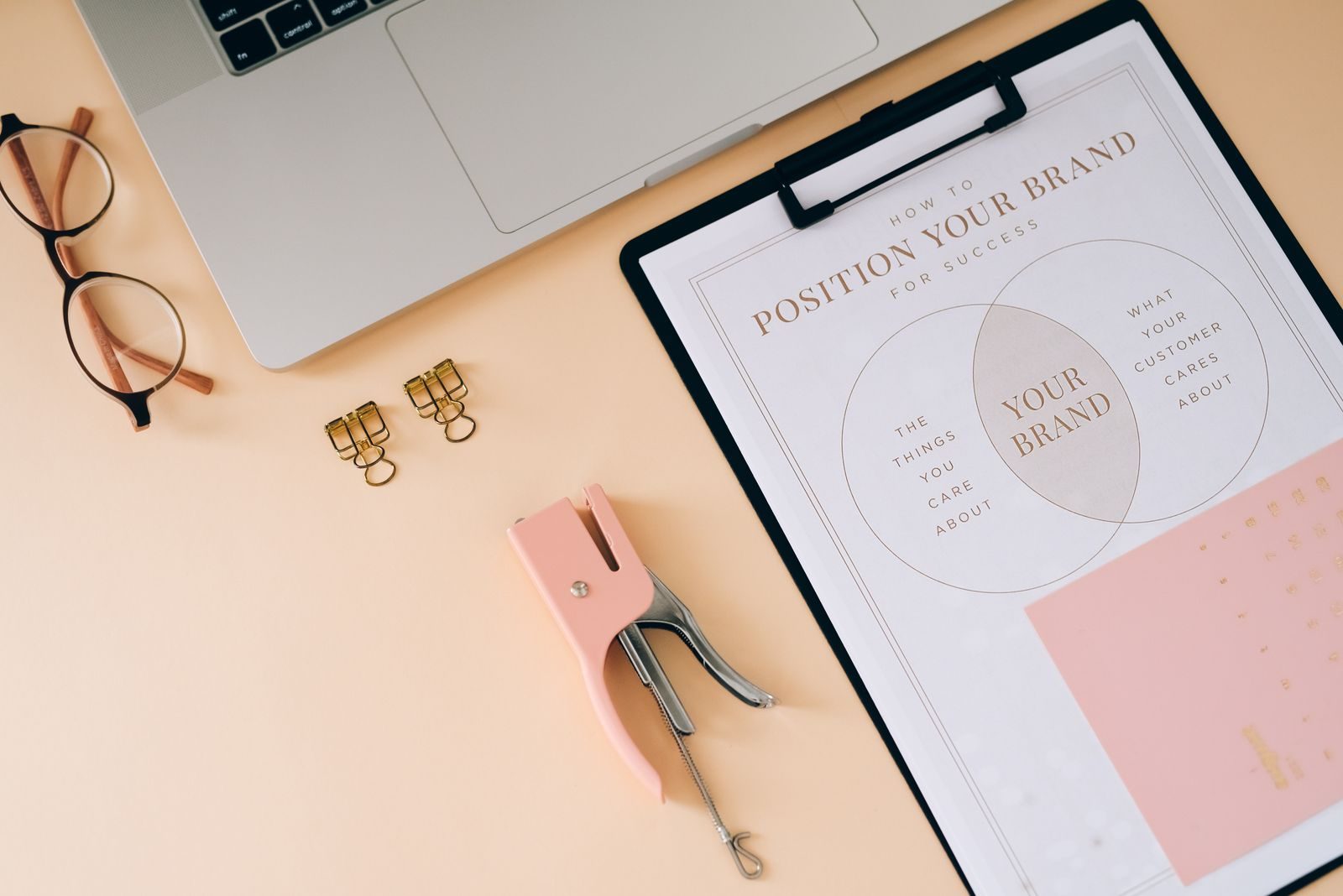 Flat lay com itens de escritório e prancheta de estratégia de marca em um espaço de trabalho moderno