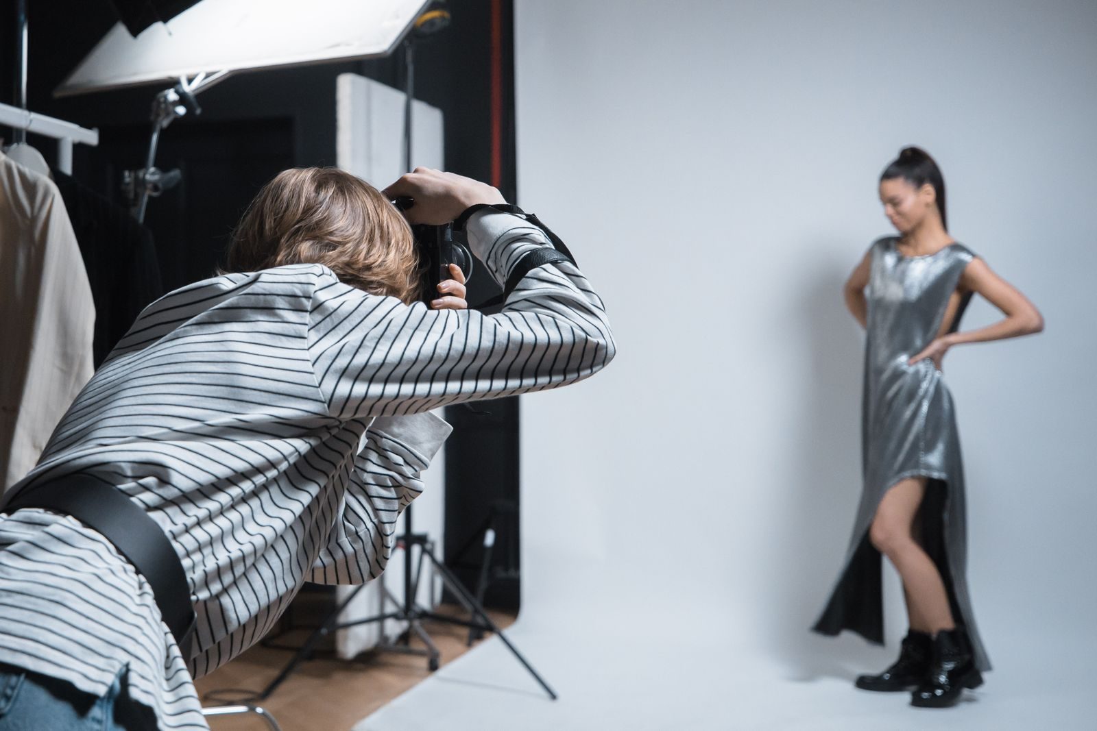 Fotógrafo fotografando uma modelo posando em estúdio