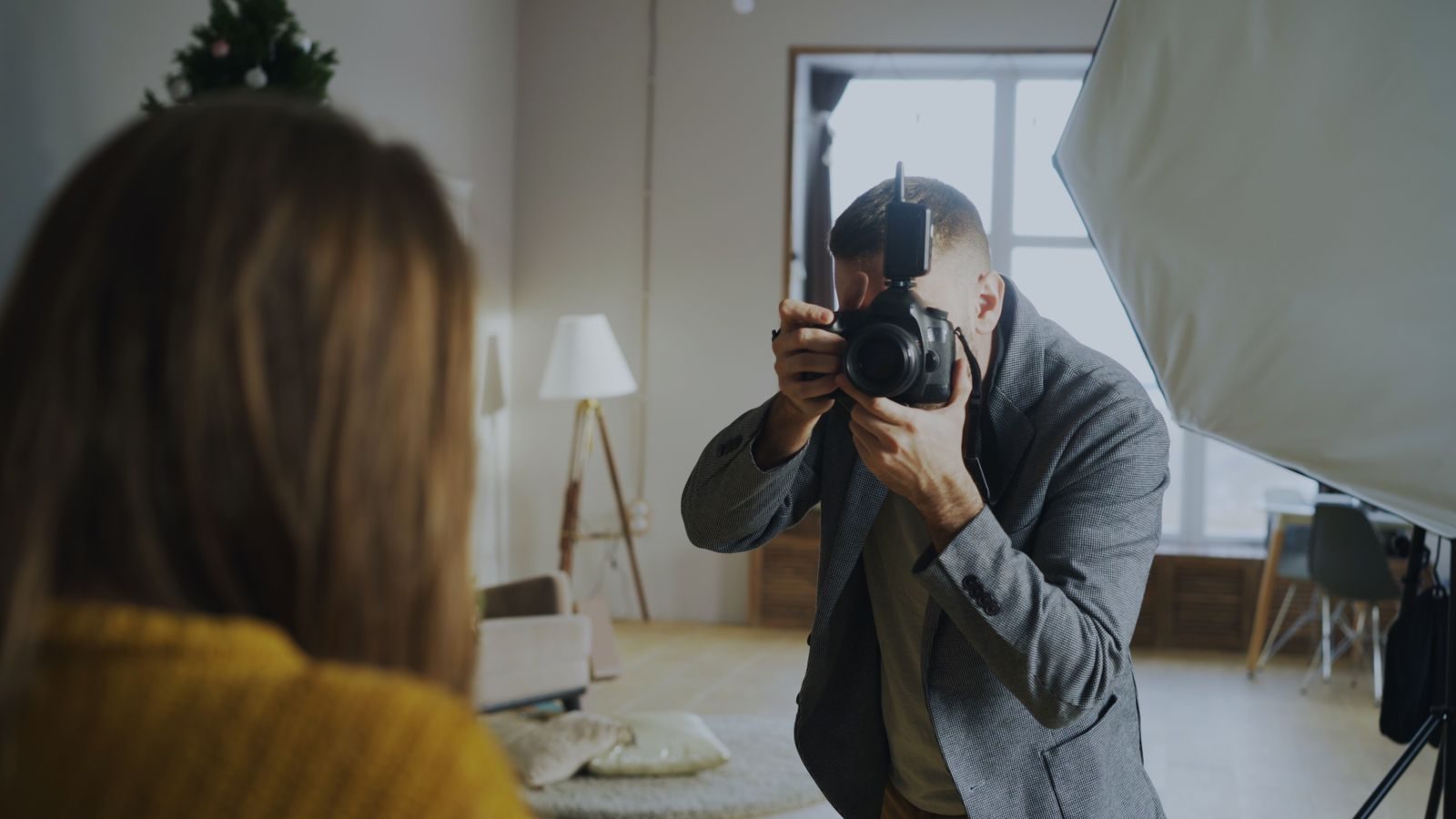 Fotógrafo fazendo retrato em estúdio interno bem iluminado