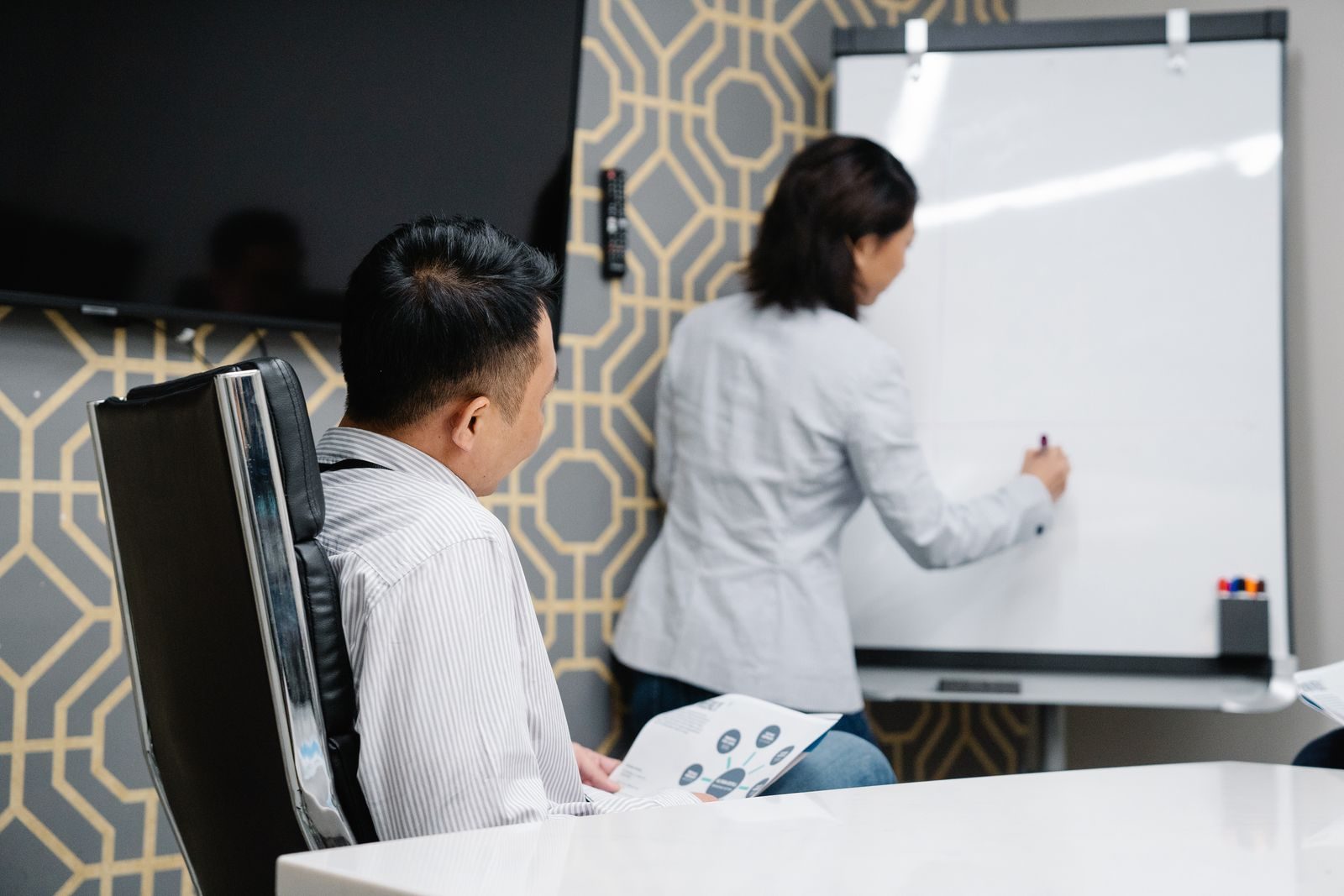 Profissionais em reunião colaborativa usando quadro branco para brainstorming