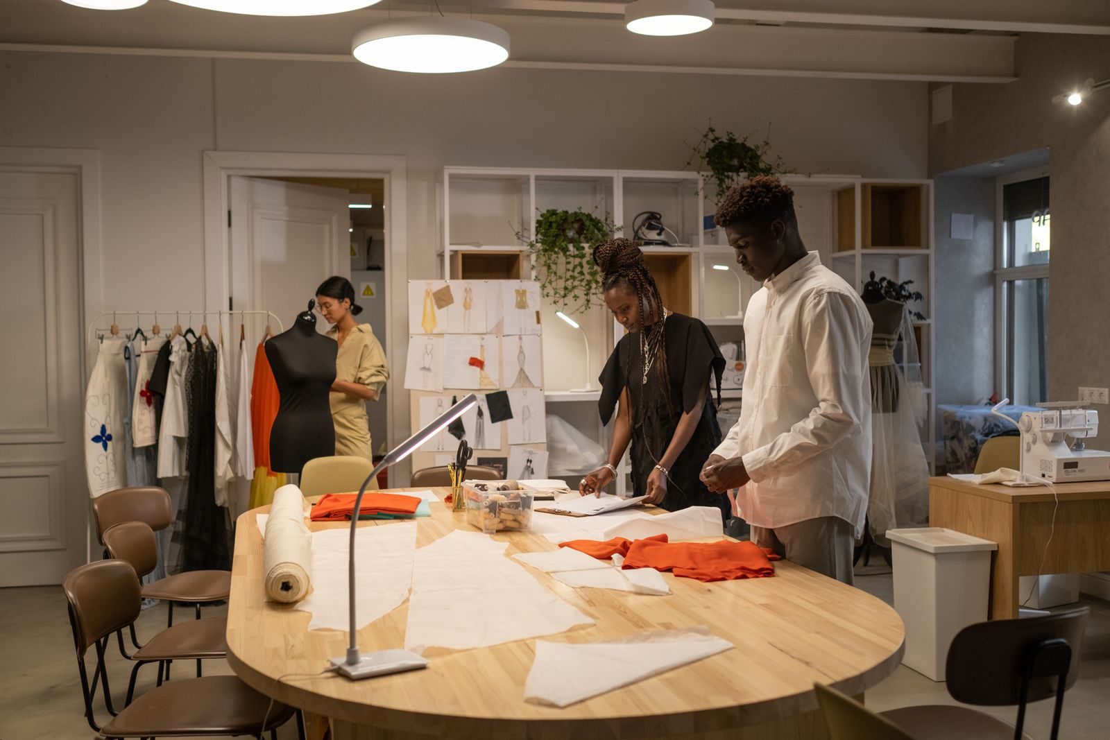 Estilistas trabalhando juntos em um estúdio elegante, criando roupas e ideias de moda