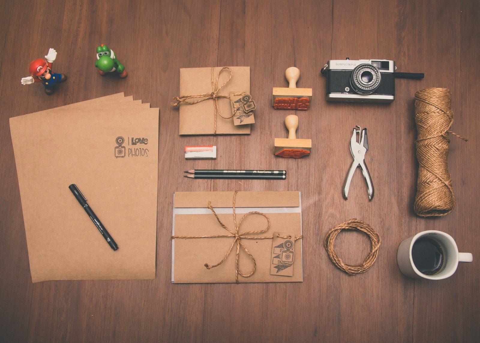 Flat lay com papel pardo, caneca, lápis e câmera