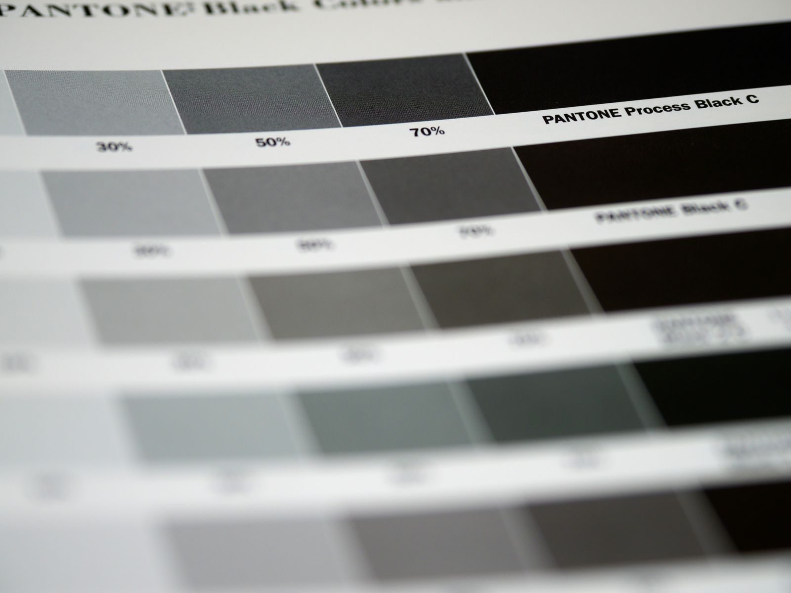 Close de amostras de cor preta Pantone com vários tons e porcentagens